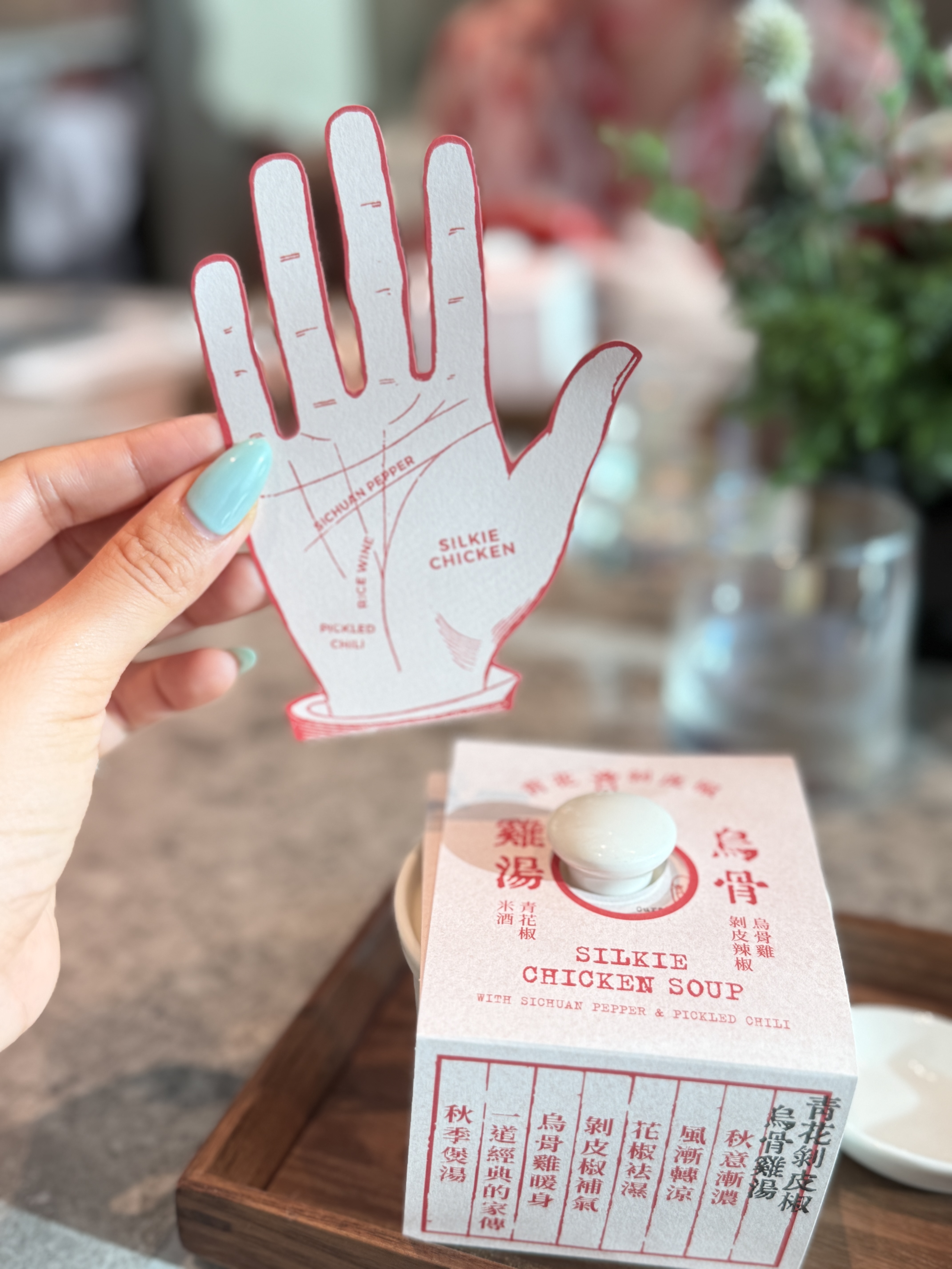 盛裝雞湯的盒裝設計藏有巧思,打開後可取出手掌造型風味卡,將烏骨雞、剝皮辣椒、青花椒等食材一一標示,呼應秋日食補的中醫養生概念。