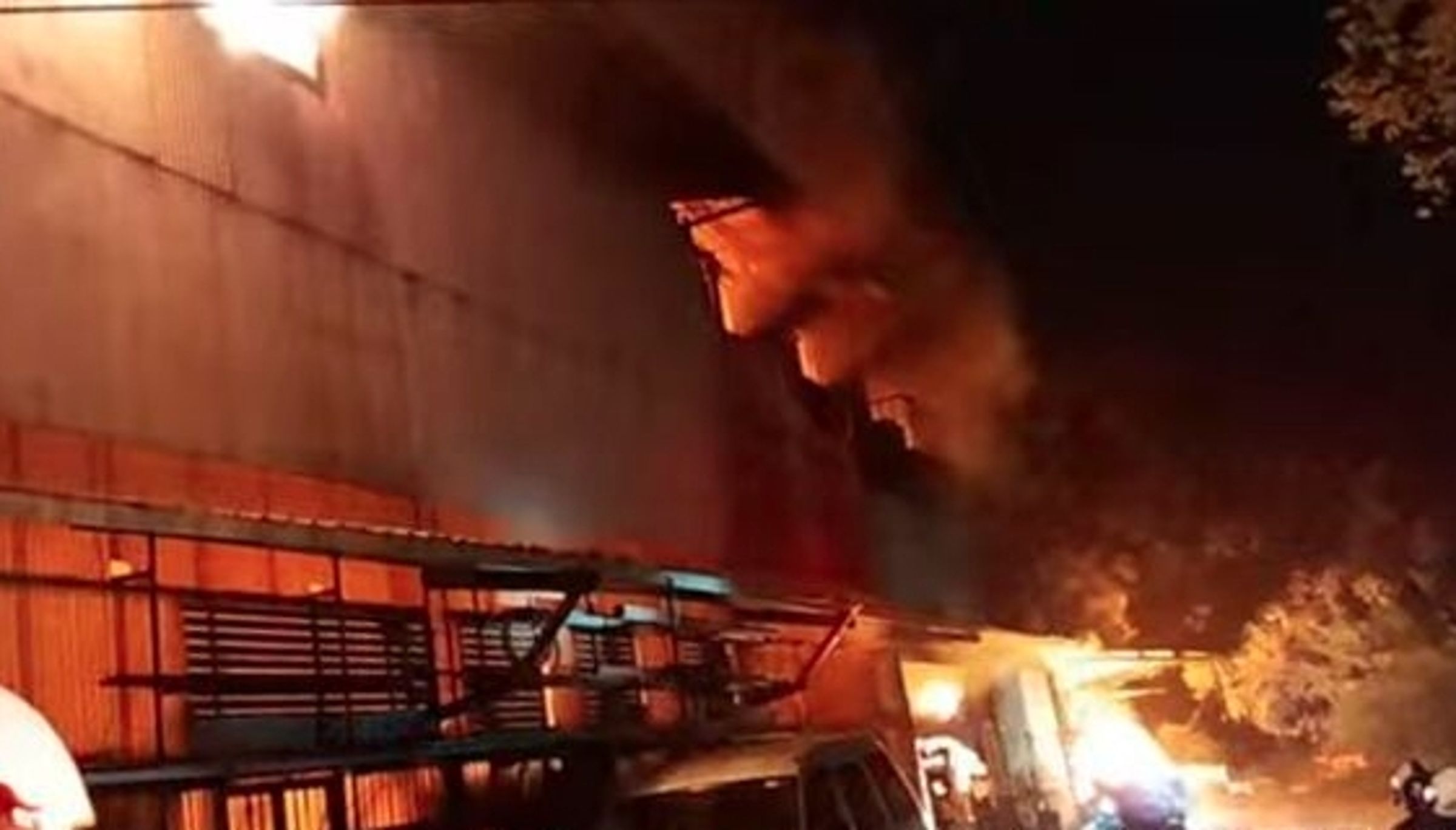 台北市南港區研究院路四段一處鐵皮工廠今日凌晨發生嚴重火警，現場火舌吞噬整座建物。（翻攝畫面）