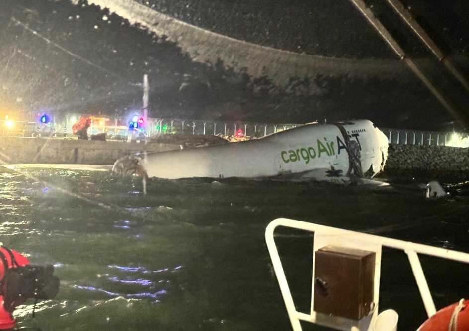 阿聯酋航空貨機疑似降落失控衝出北跑道，部分機身跌入海中，現場緊急封鎖。（翻攝自X /  BNO News Live）