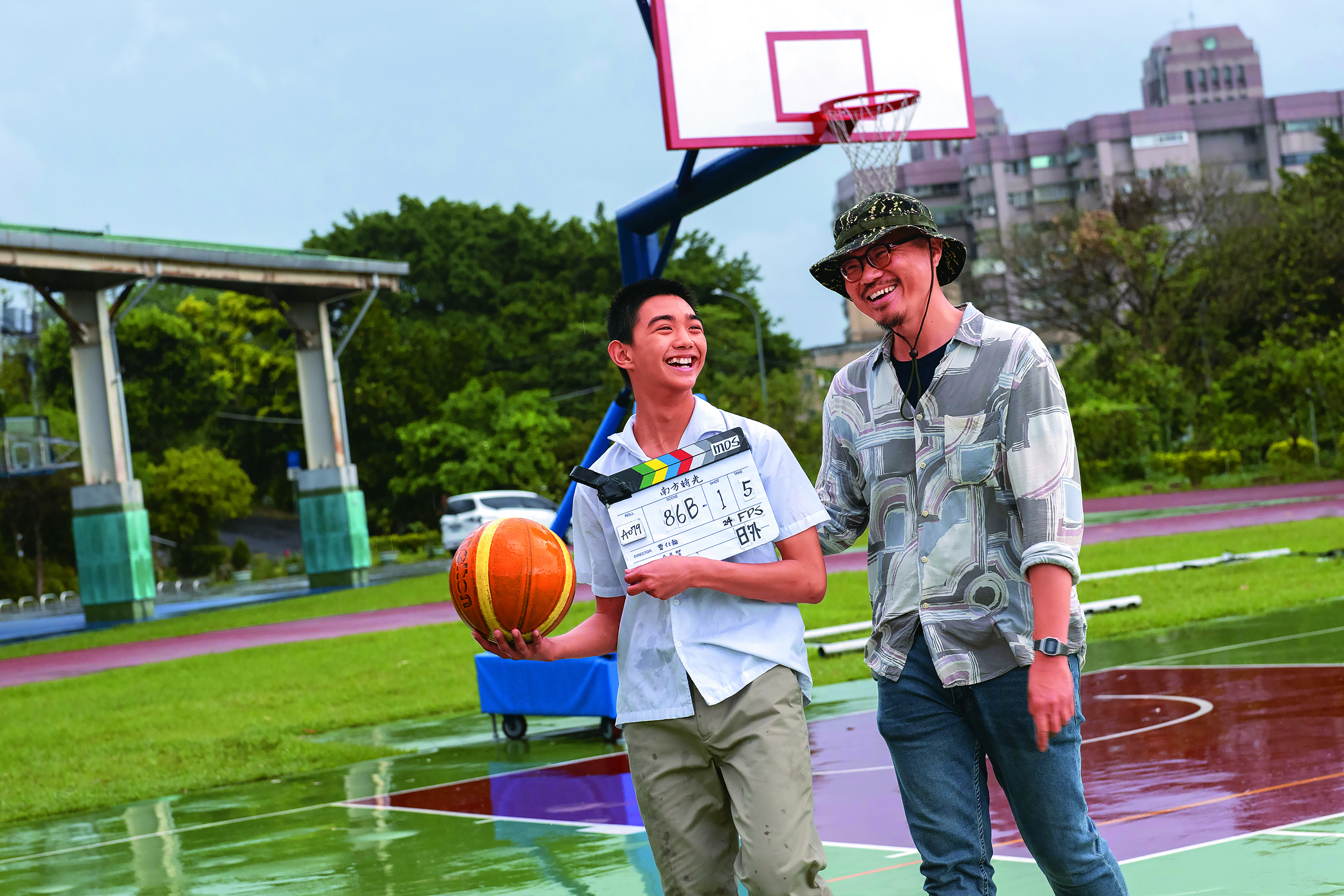 導演曹仕翰（右）與海選相中的男主角陳玄力（左）在拍片現場輕鬆互動。（百景映畫提供）