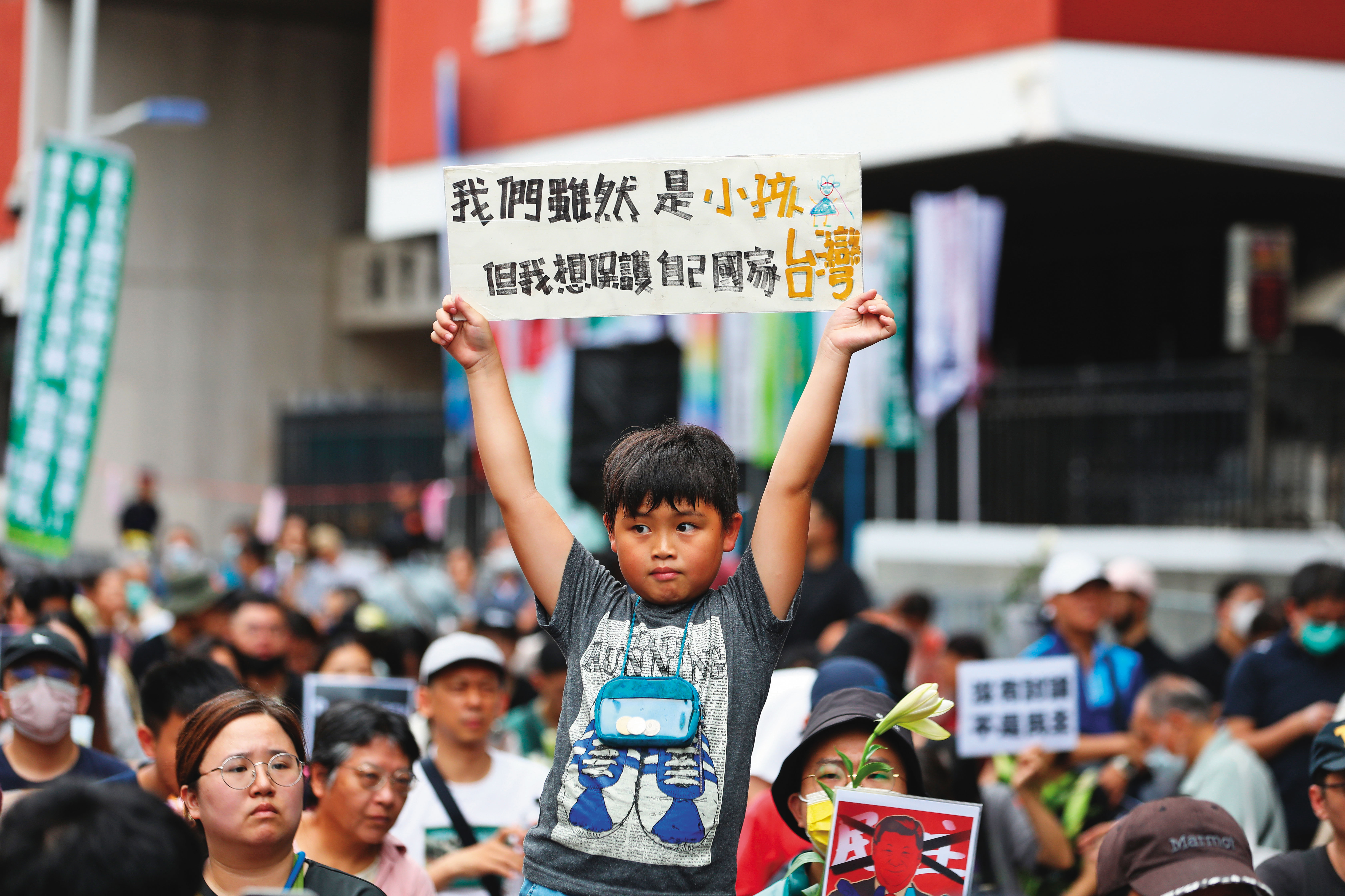 立院外小朋友手舉著「我們雖然是小孩但我想保護自己國家台灣」的看板。