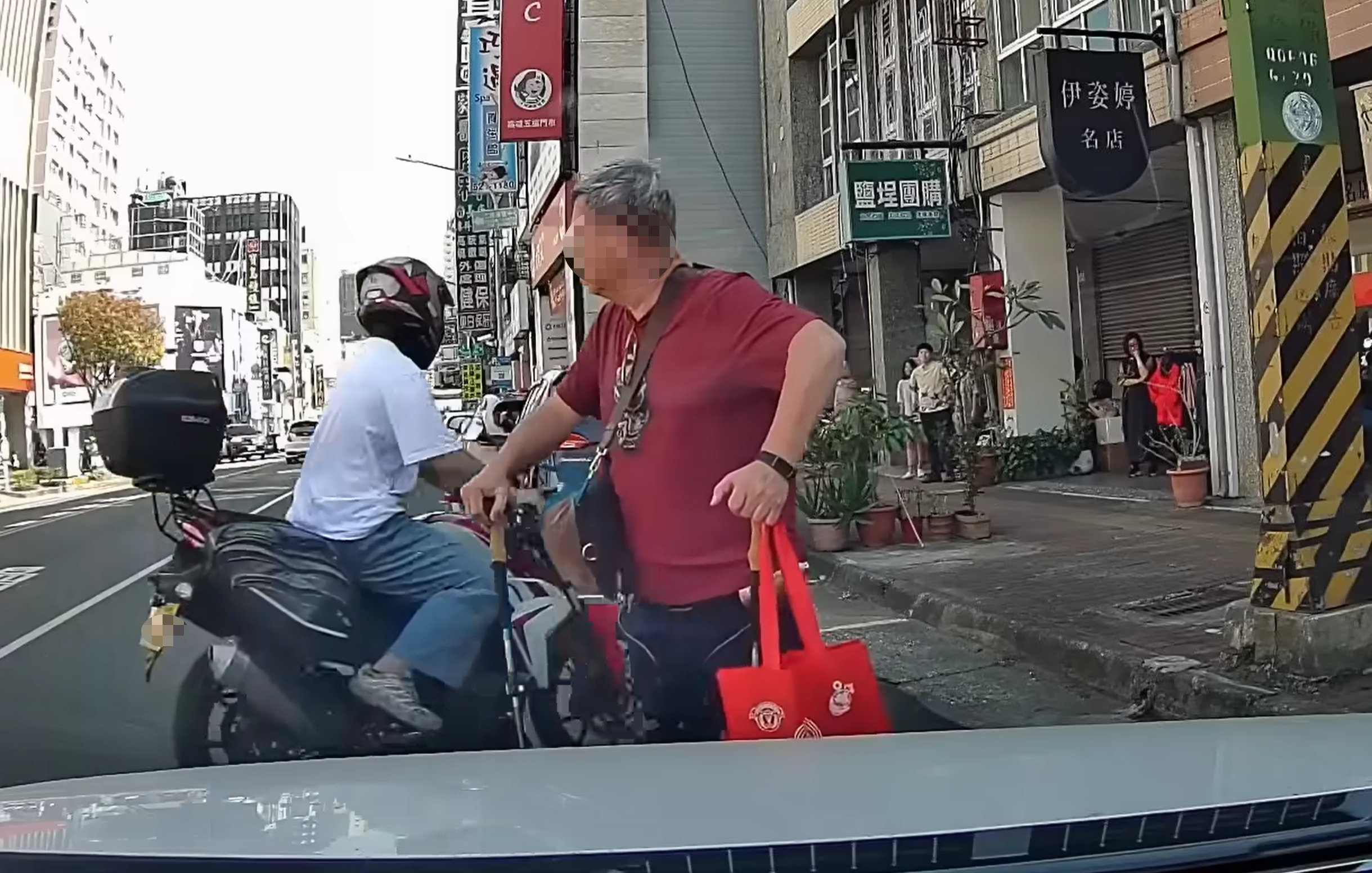 一名紅衣阿伯日前在高雄市街頭以人肉方式占位，駕駛要停車堅持不讓，豈料突然有黃牌重機騎士直接停入，讓他當場傻眼，原因僵持場面也瞬間落幕。（翻攝自「WoWtchout-地圖型行車影像分享平台」YT頻道）
