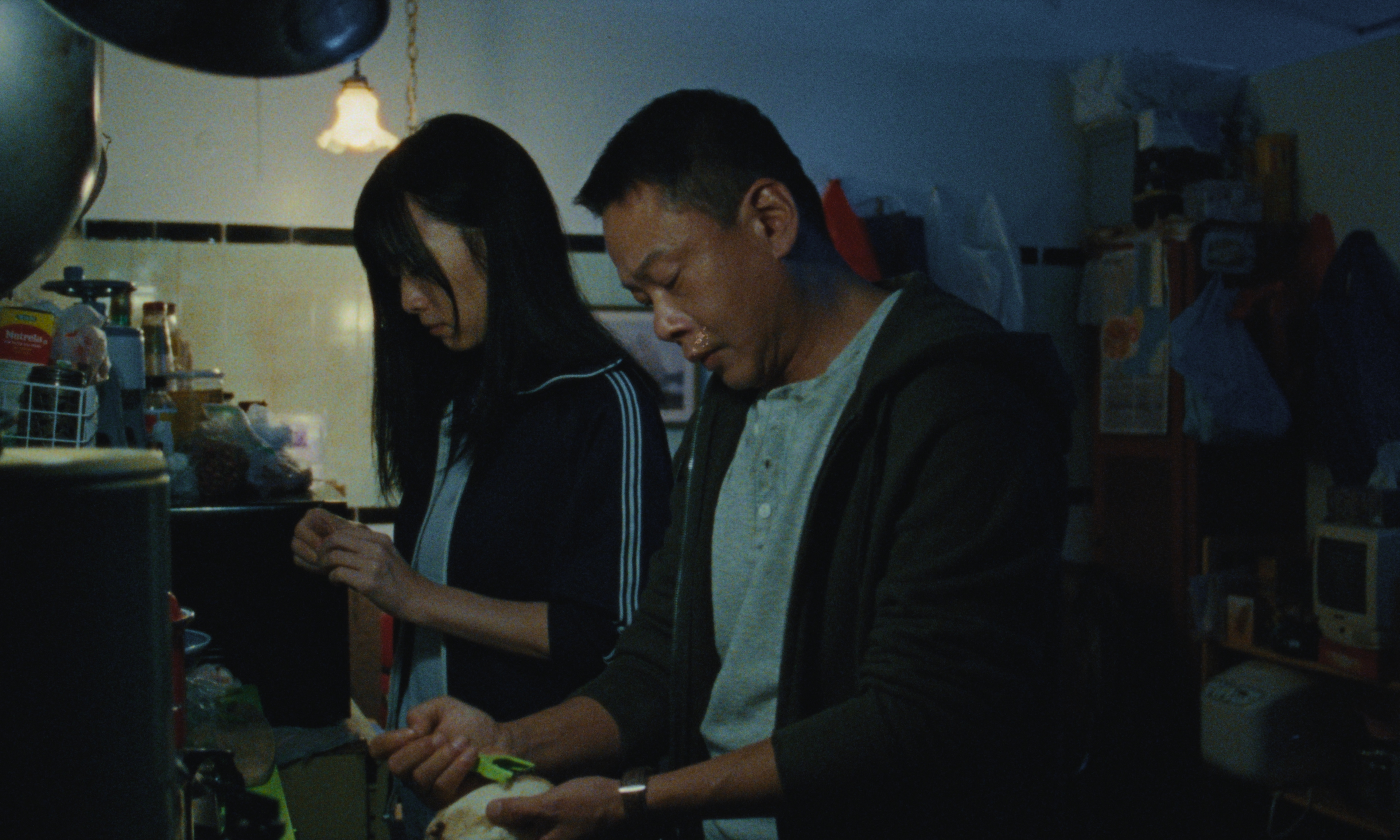 李康生（右）在《藍色太陽宮》飾演從台灣逃至美國的落魄中年男子。（可樂電影提供）