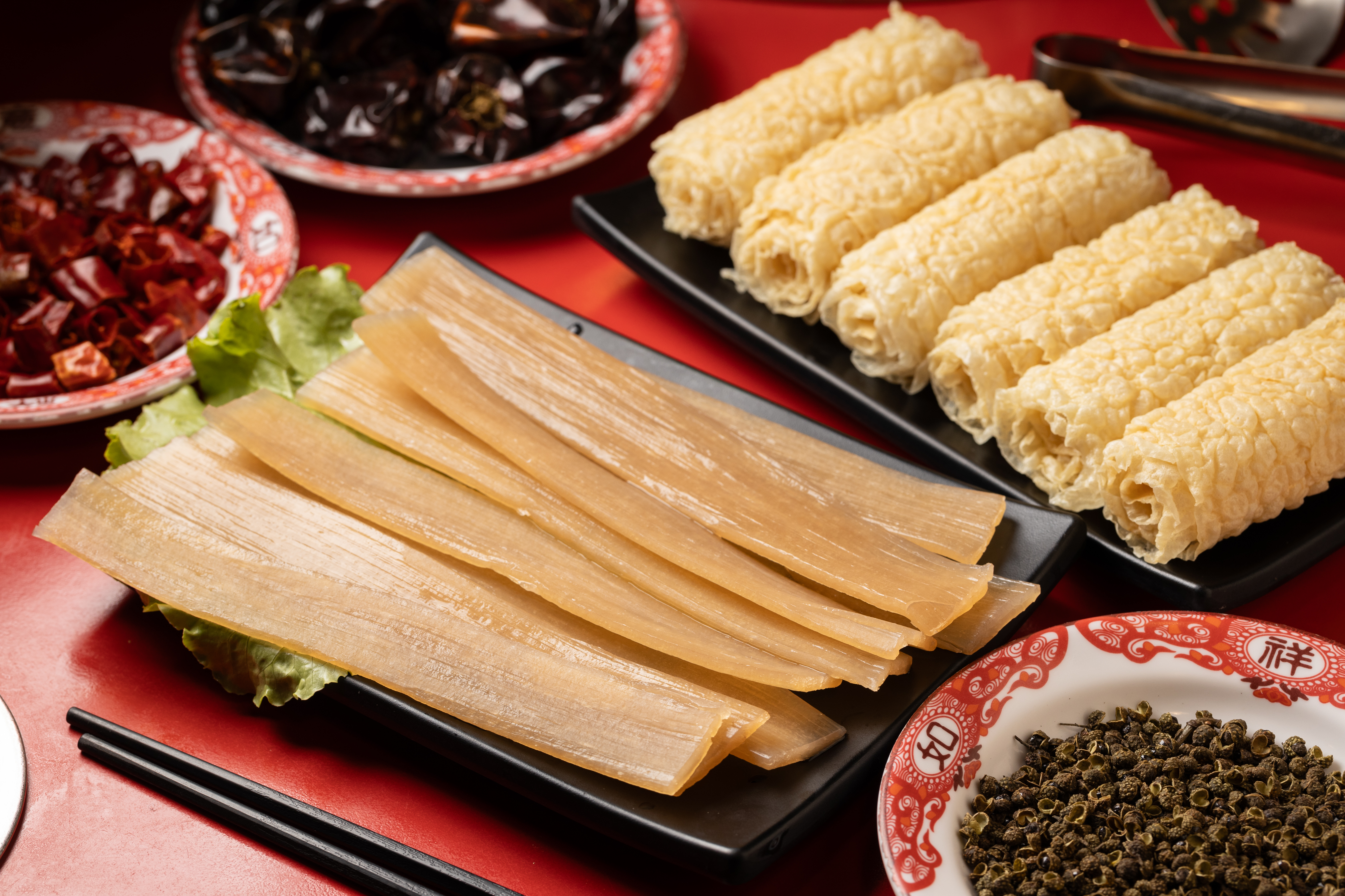 老饕必點的「紅薯寬粉」（前，100元／份）與油炸後的薄豆皮捲「響鈴卷」（後，80元／份）。