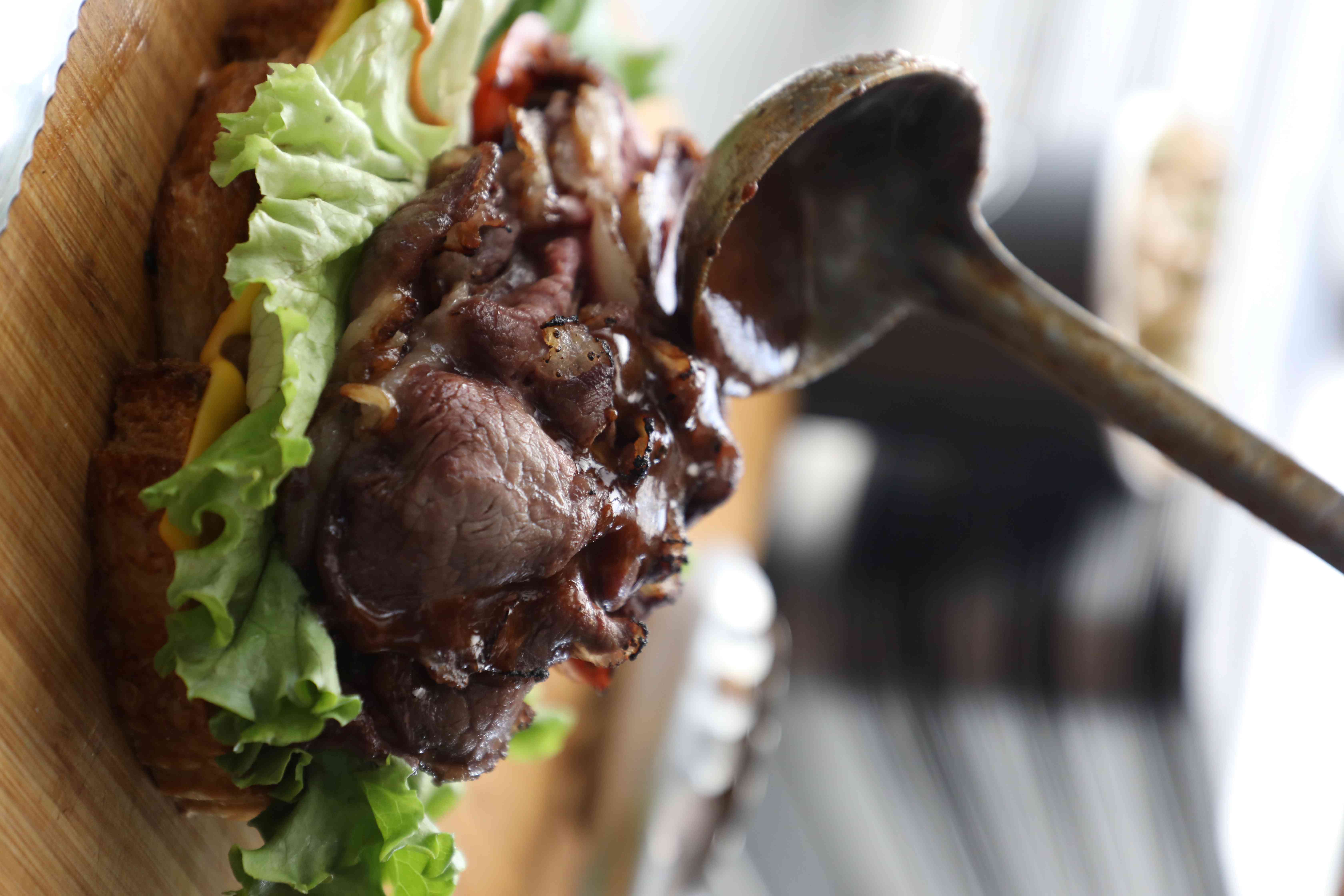 麵包、牛肉組裝完成後淋上醬汁。