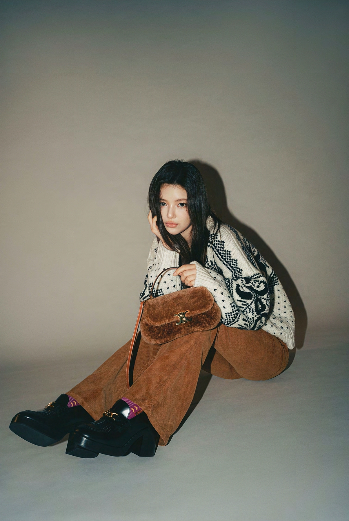 韓國女團NewJeans的Danielle身上行頭：Triomphe費爾島羊毛圓領毛衣、Marco燈芯絨牛仔褲NT$45,000、ess拋光牛皮革樂福鞋、Teen CELINE Lola羊毛革及牛皮革手袋NT$110,000。（CELINE提供）