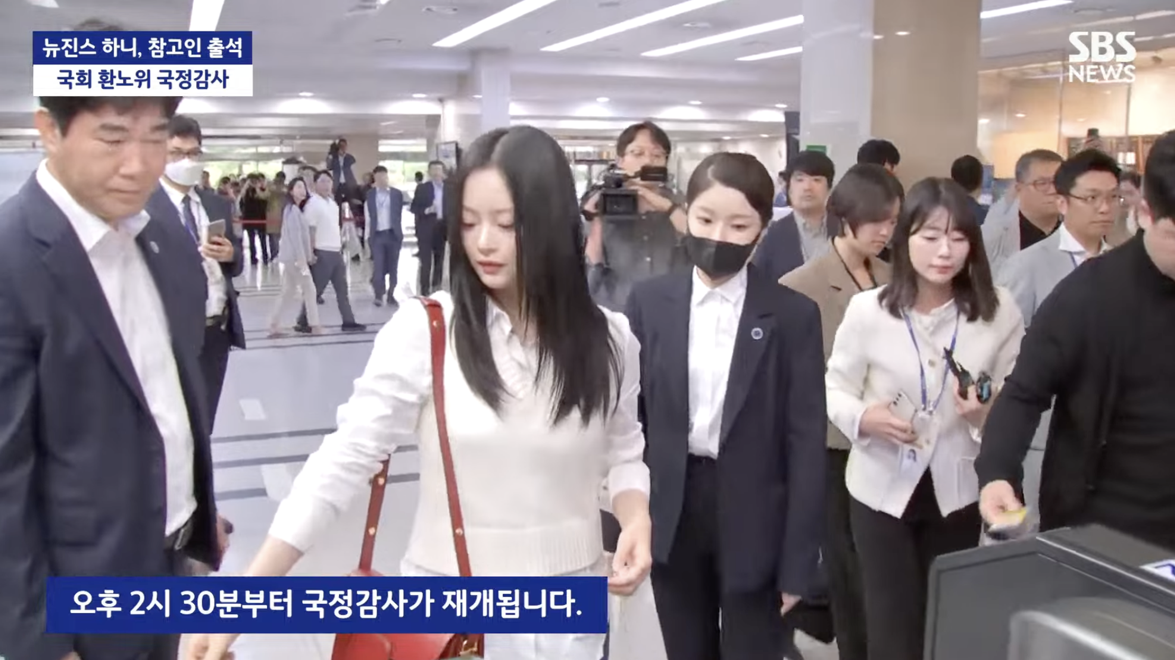 Hanni以白衣牛仔褲現身韓國國會。(截圖自SBS News YT)