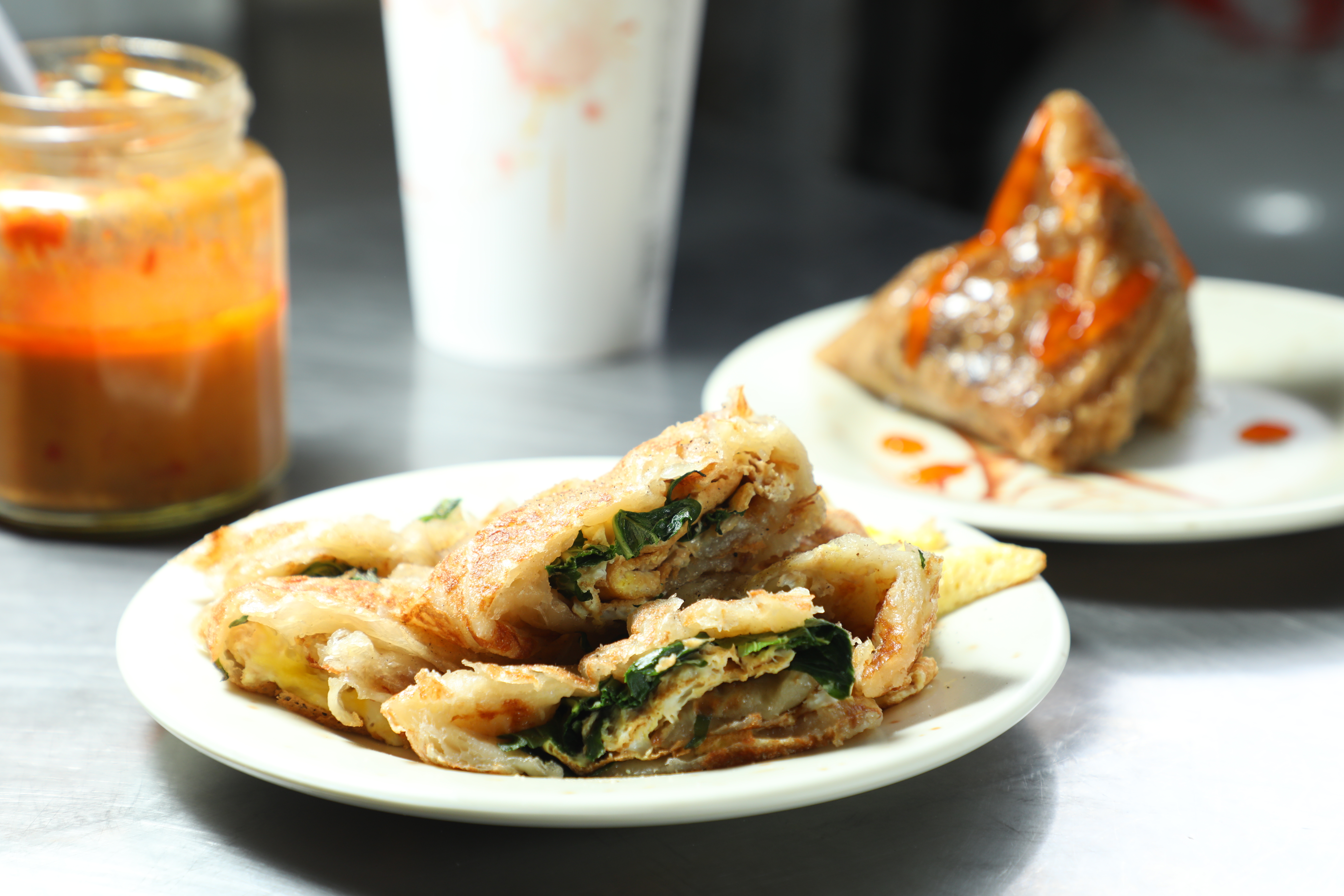 當地人從小吃到大的早餐店「正珍香包子」，自製香Q後餅皮的「九層塔蛋抓餅」（前，65元／個）與古早味「肉粽」（後，45元／個）都是人氣招牌。