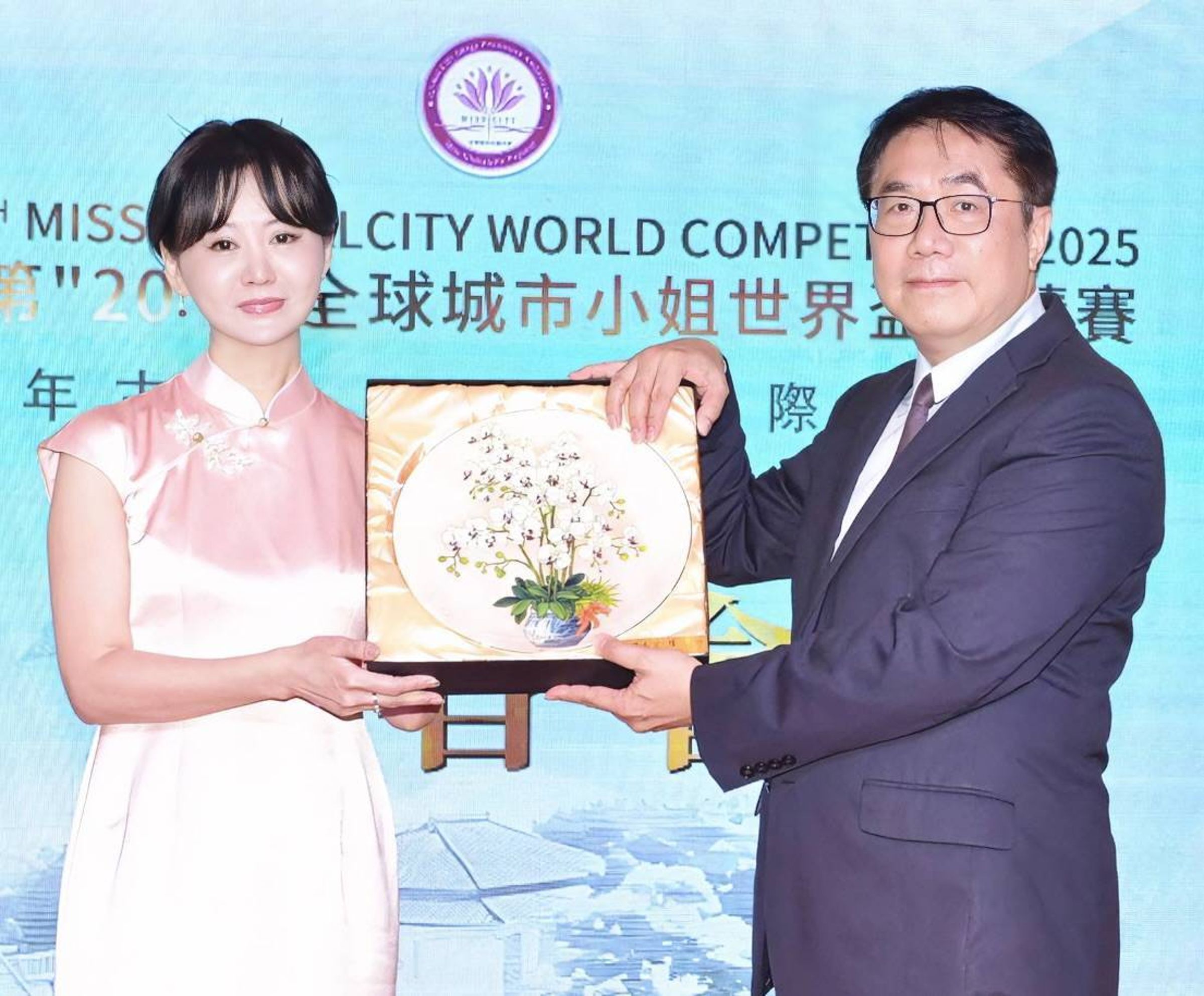 台南市長黃偉哲(右)致贈蘭花瓷盤給張如君,預祝選拔大賽圓滿成功。(中華全球城市選拔協會提供)