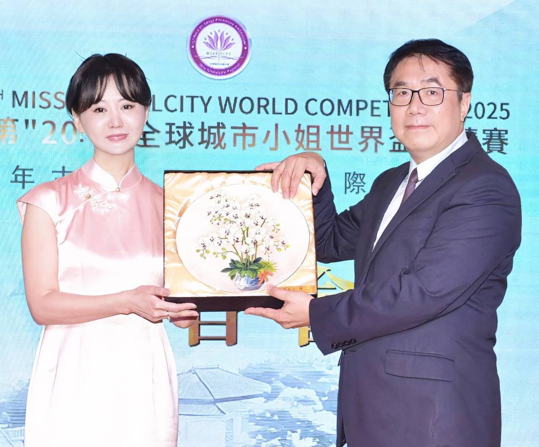 台南市長黃偉哲（右）致贈蘭花瓷盤給張如君，預祝選拔大賽圓滿成功。（中華全球城市選拔協會提供）