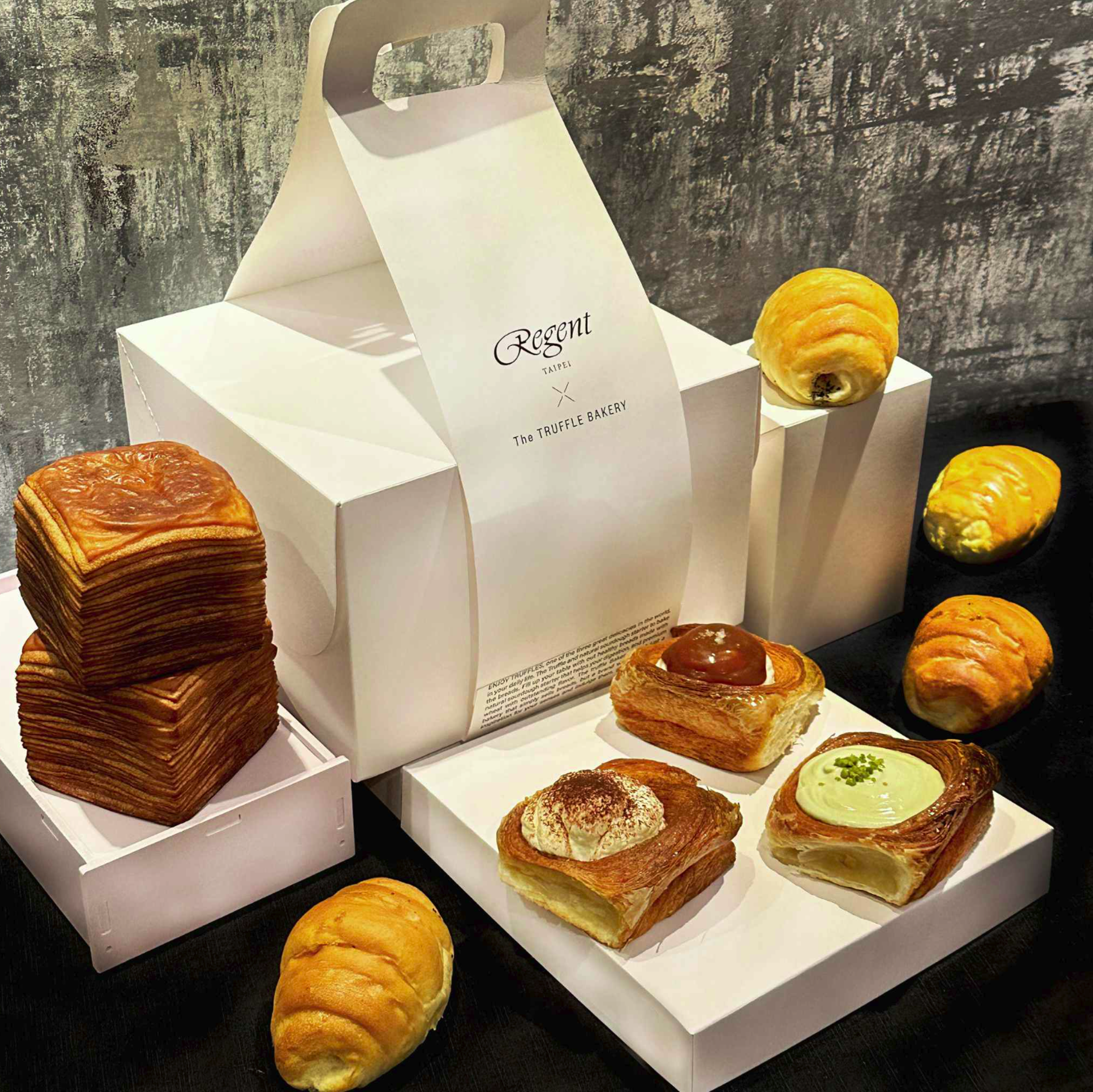 「The TRUFFLE BAKERY 美饌禮盒 Gourmet Gift Box」內含「經典奶油紙巾吐司」與「巧克力紙巾吐司」兩種口味;以及「岩鹽奶油捲」「松露岩鹽奶油捲」各2入;與「開心果倫敦麵包」「焦糖海鹽倫敦麵包」「提拉米蘇倫敦麵包」。(1,580元/組,晶華酒店提供)