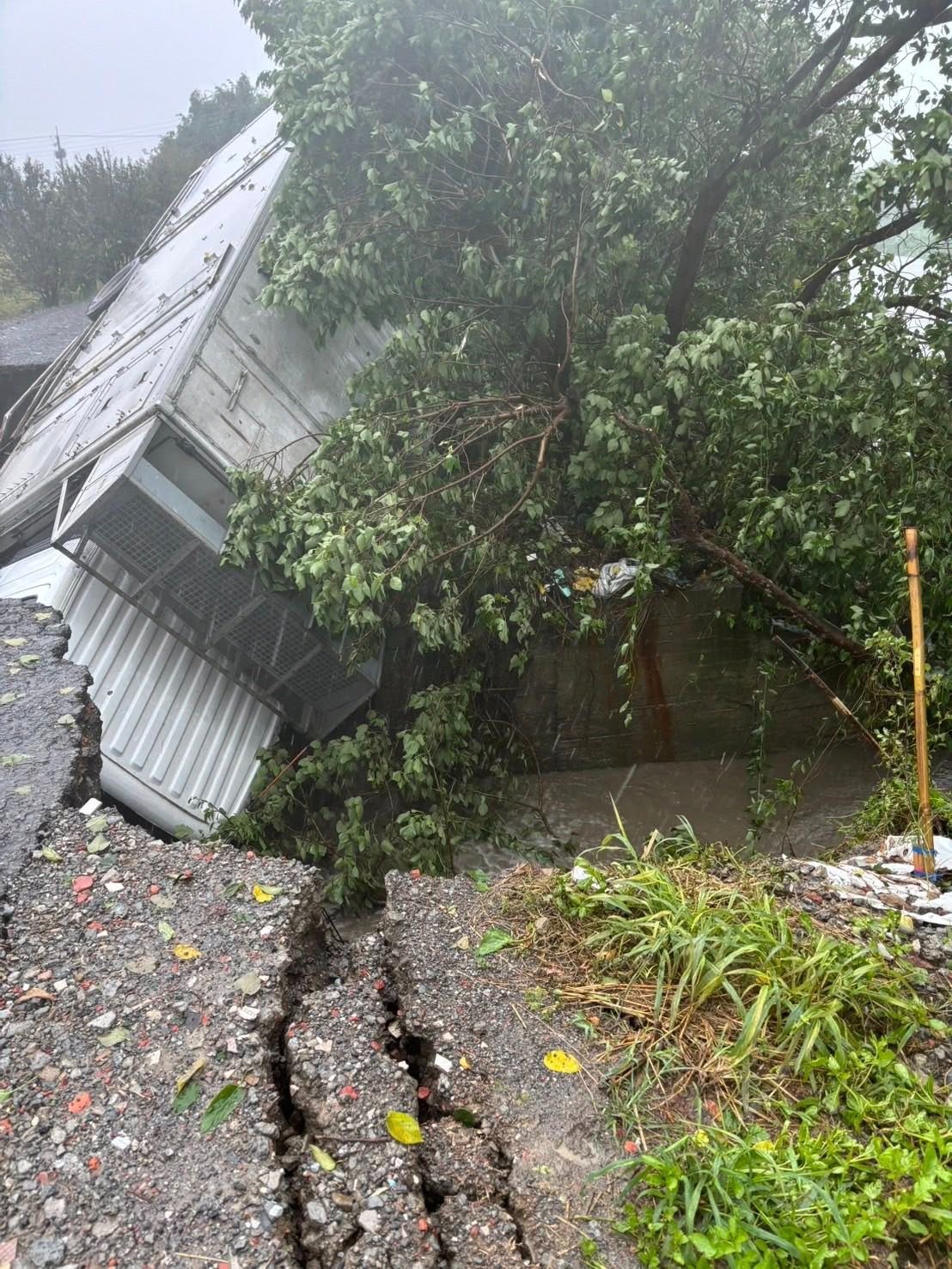 彰化縣二林鎮受強降雨影響，地面出現天坑，大貨車受困動彈不得。（翻攝自彰化縣媒體記者協會）