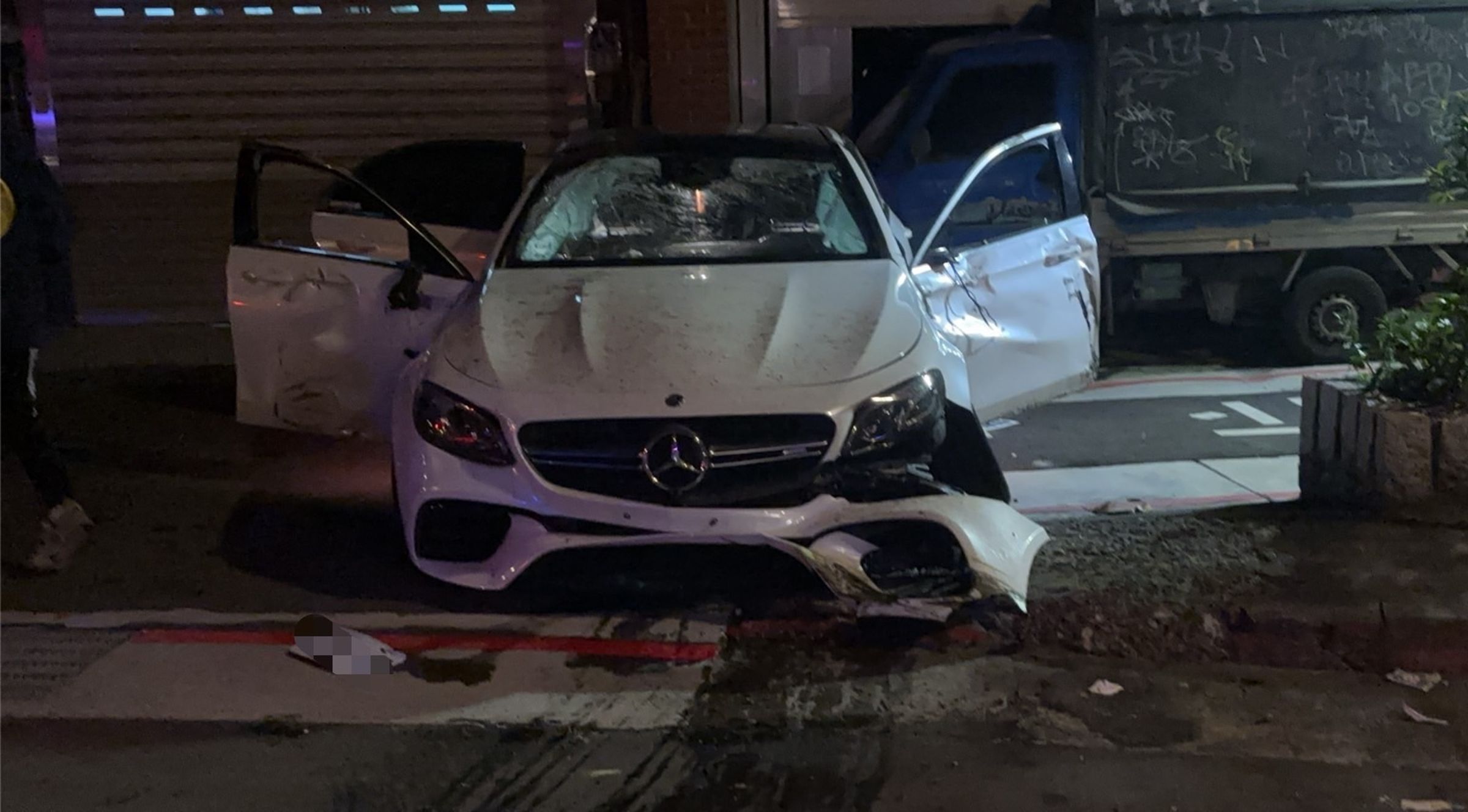 李男租來的賓士車自撞分隔島後翻覆，車頭多處毀損。（翻攝畫面）