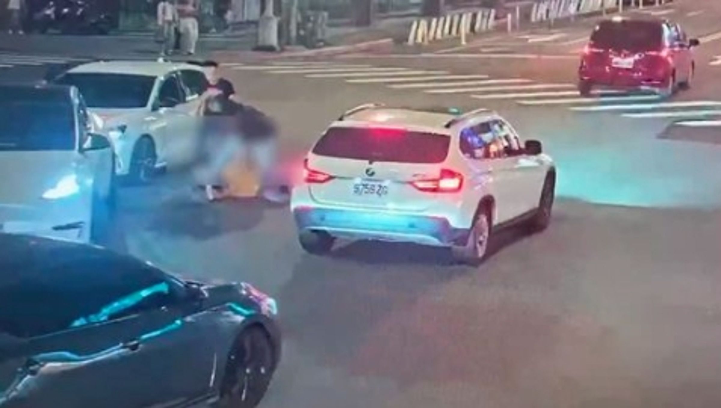 特斯拉車主被後方車輛逼車，憤而下車找其理論，反遭對方痛毆。（翻攝畫面）
