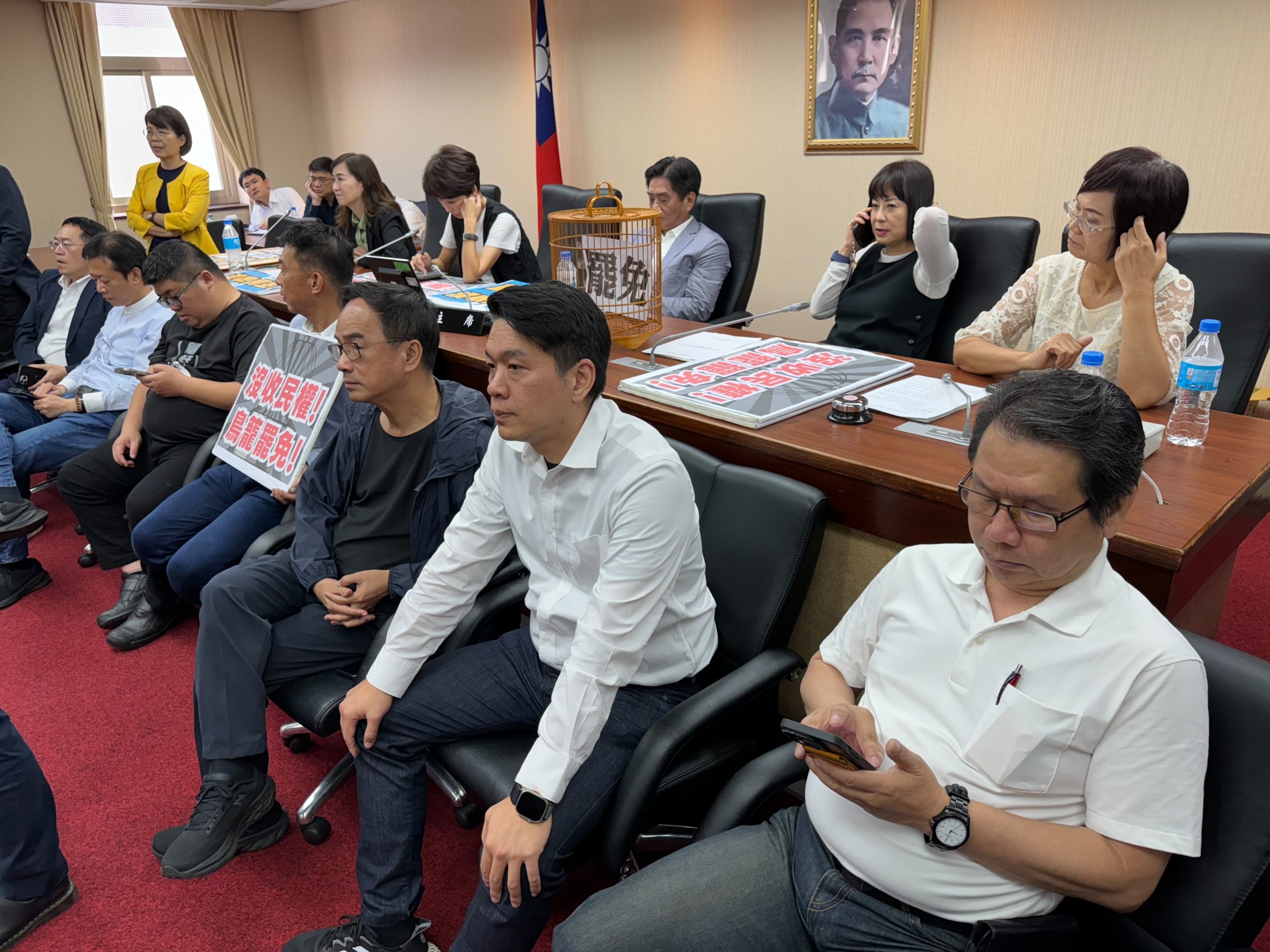 民進黨立委一群人一大早就拿著布條，佔領內政委員會主席台。