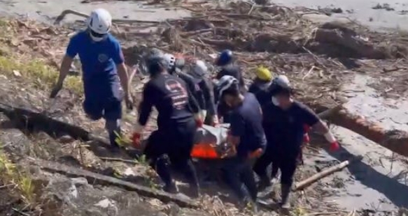 搜救人員在花蓮溪河道發現遺體，現場氣氛沉重。（翻攝畫面）