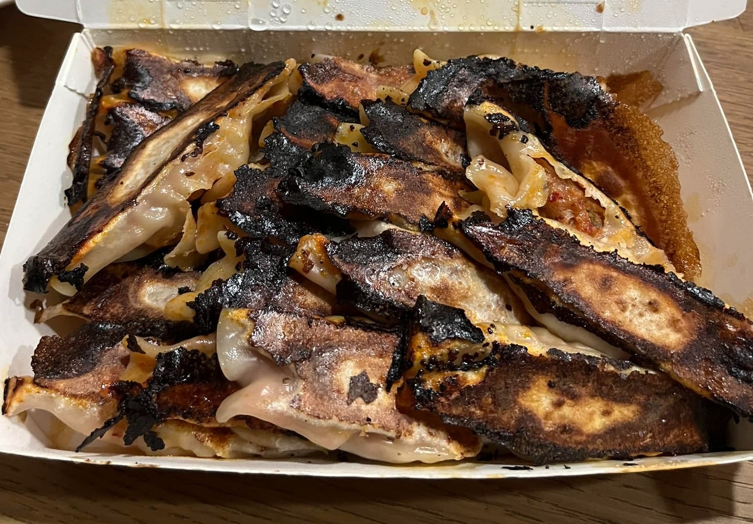 網友看到自己買的鍋貼呈焦黑一片，連吃都不敢吃。（翻攝自爆料公社二社）