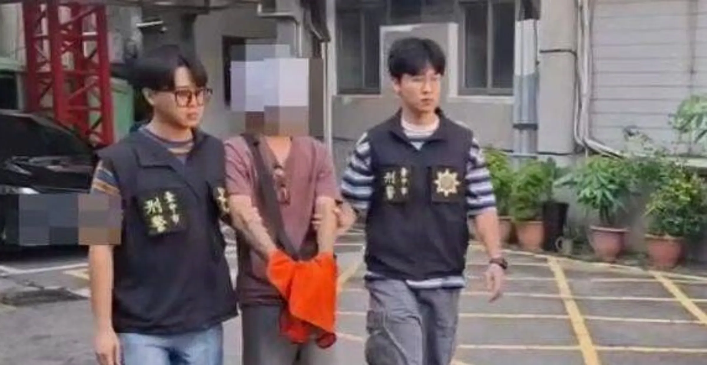 台中市日前發生賓士車撞飛並二度輾斃38歲陳姓女護理師的重大死亡車禍,30歲林姓肇事男子到案移送時頭戴安全帽並以A4紙遮擋面部、外套遮掩手銬。(翻攝畫面)