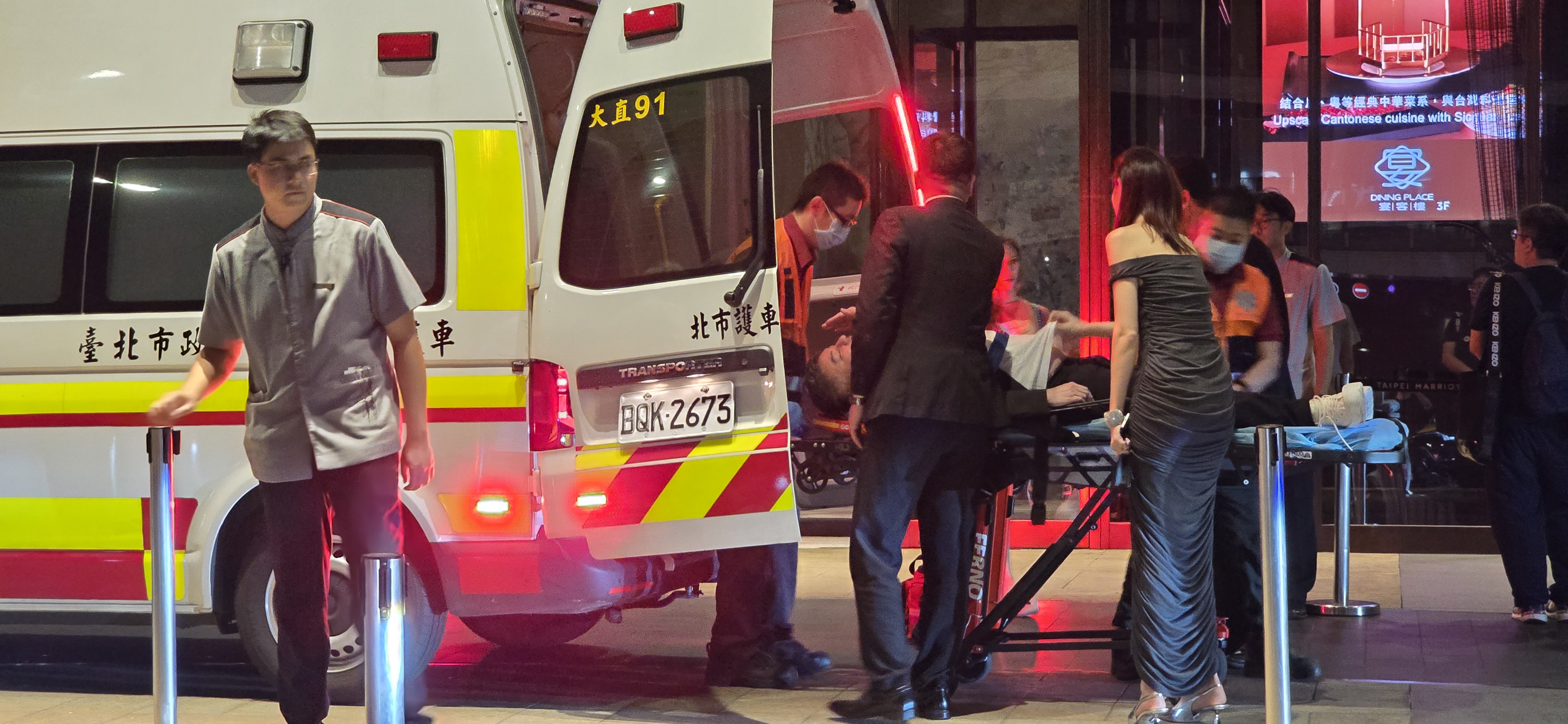 詹仁雄被攙扶到救護車前後，被抬上擔架上車送醫。