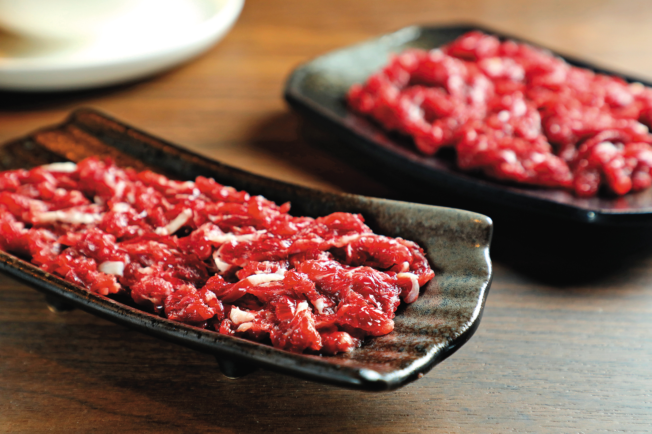饕客最愛的「頂級上選溫體牛肉」(前,480元/份)和肉質鮮甜的「溫體赤身牛肉」(後,350元/份)。