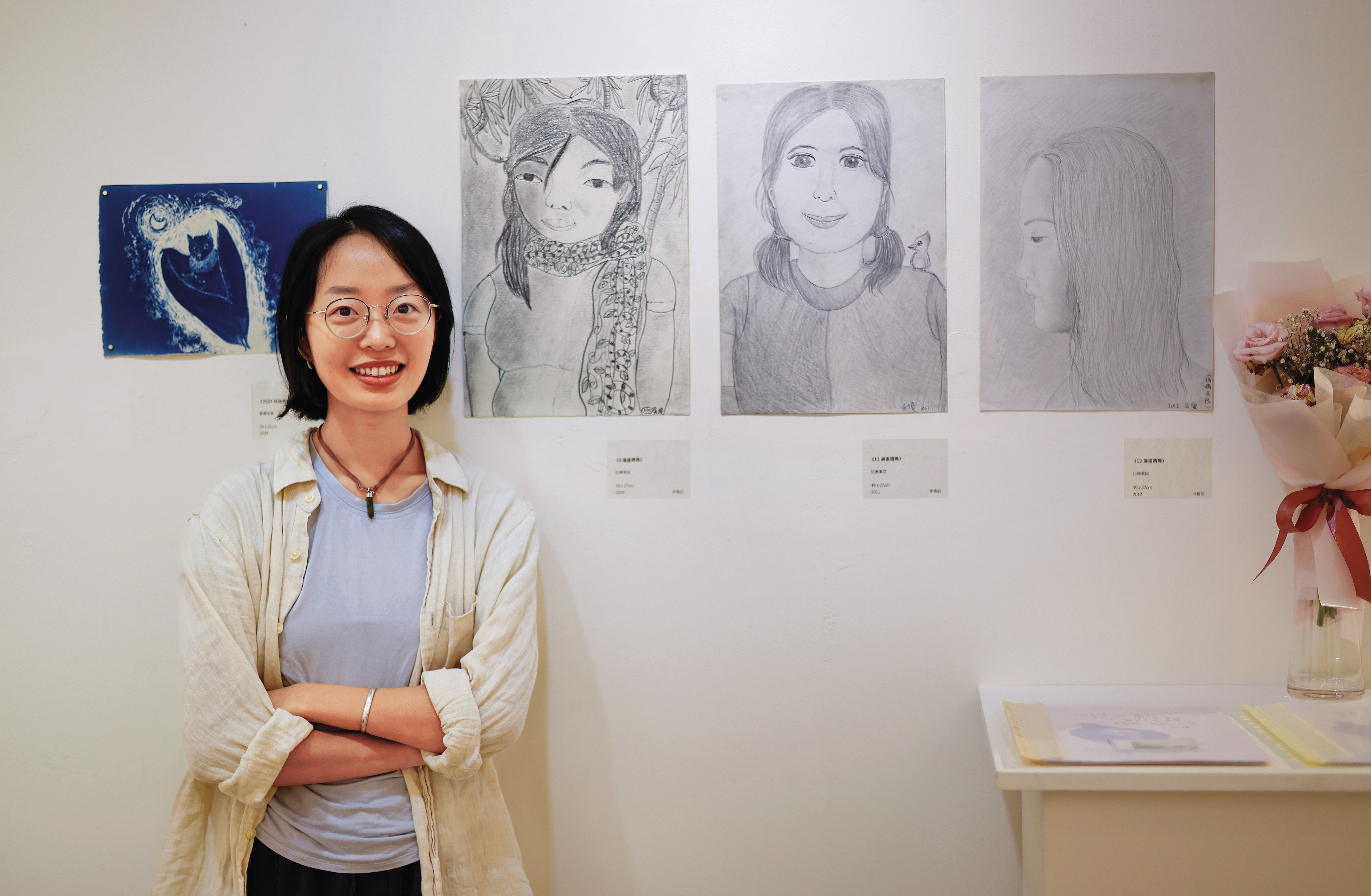吳優和母親在花蓮開聯合畫展，展出她在寫生團之外的音像、水墨畫作，過半主題也和她的花蓮生活有關。圖為她和小時候的畫作合影。