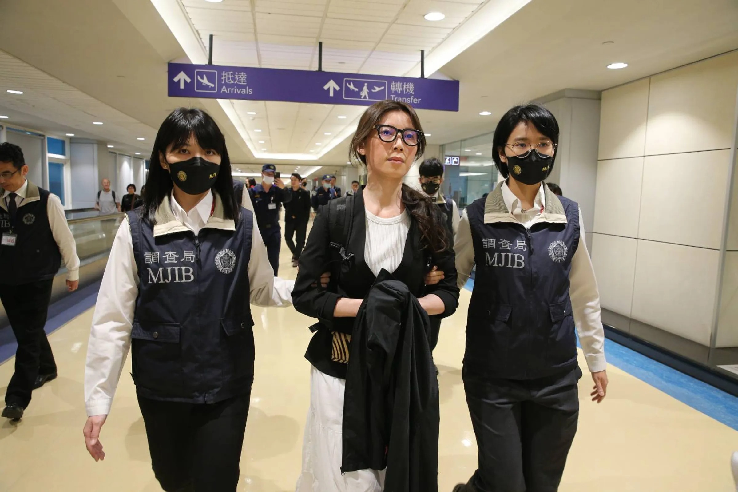 貴婦奈奈今年5月返台,被調查局人員帶往北檢。(桃園機場記者聯誼會提供)