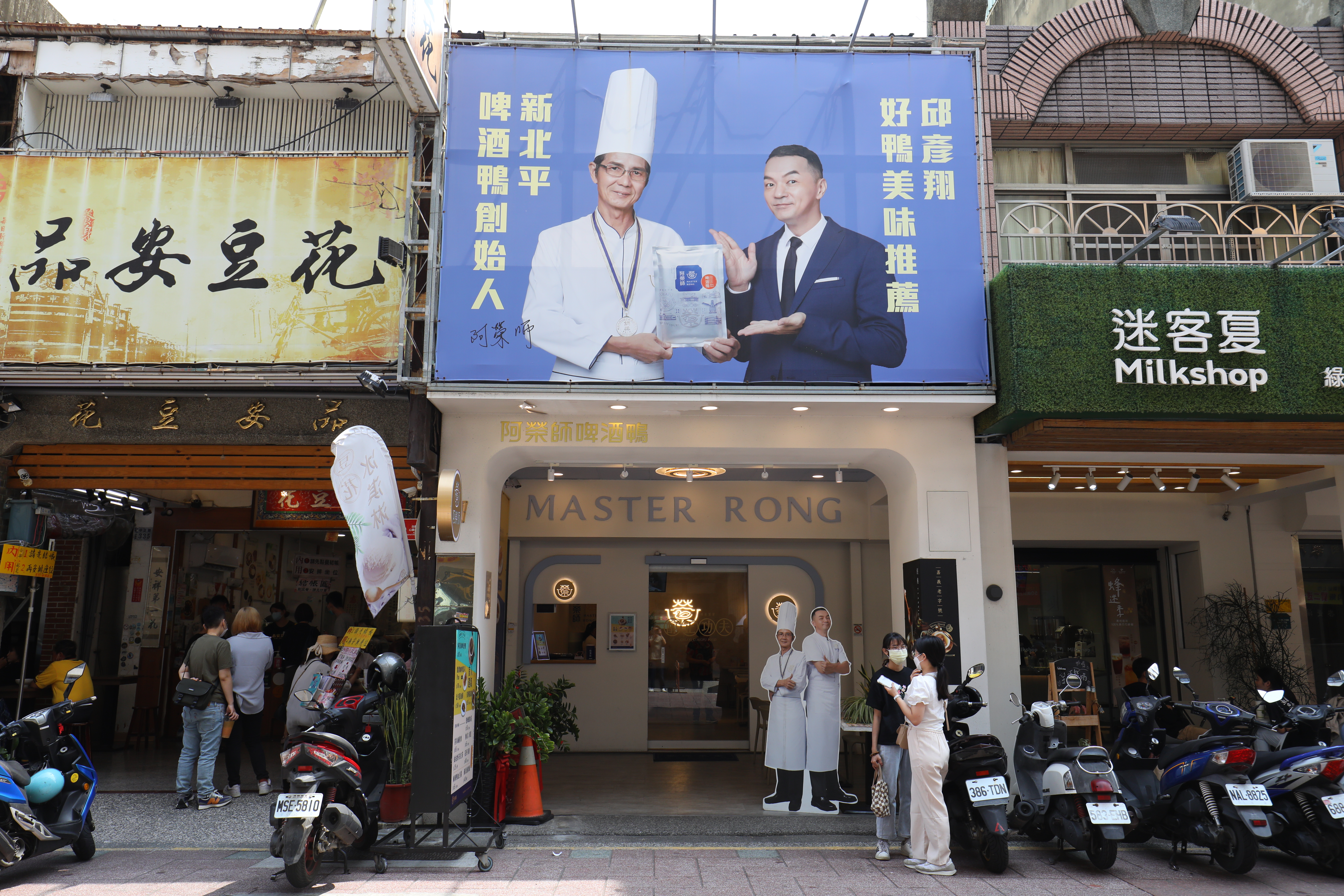 店外招牌掛著阿榮師的人像。