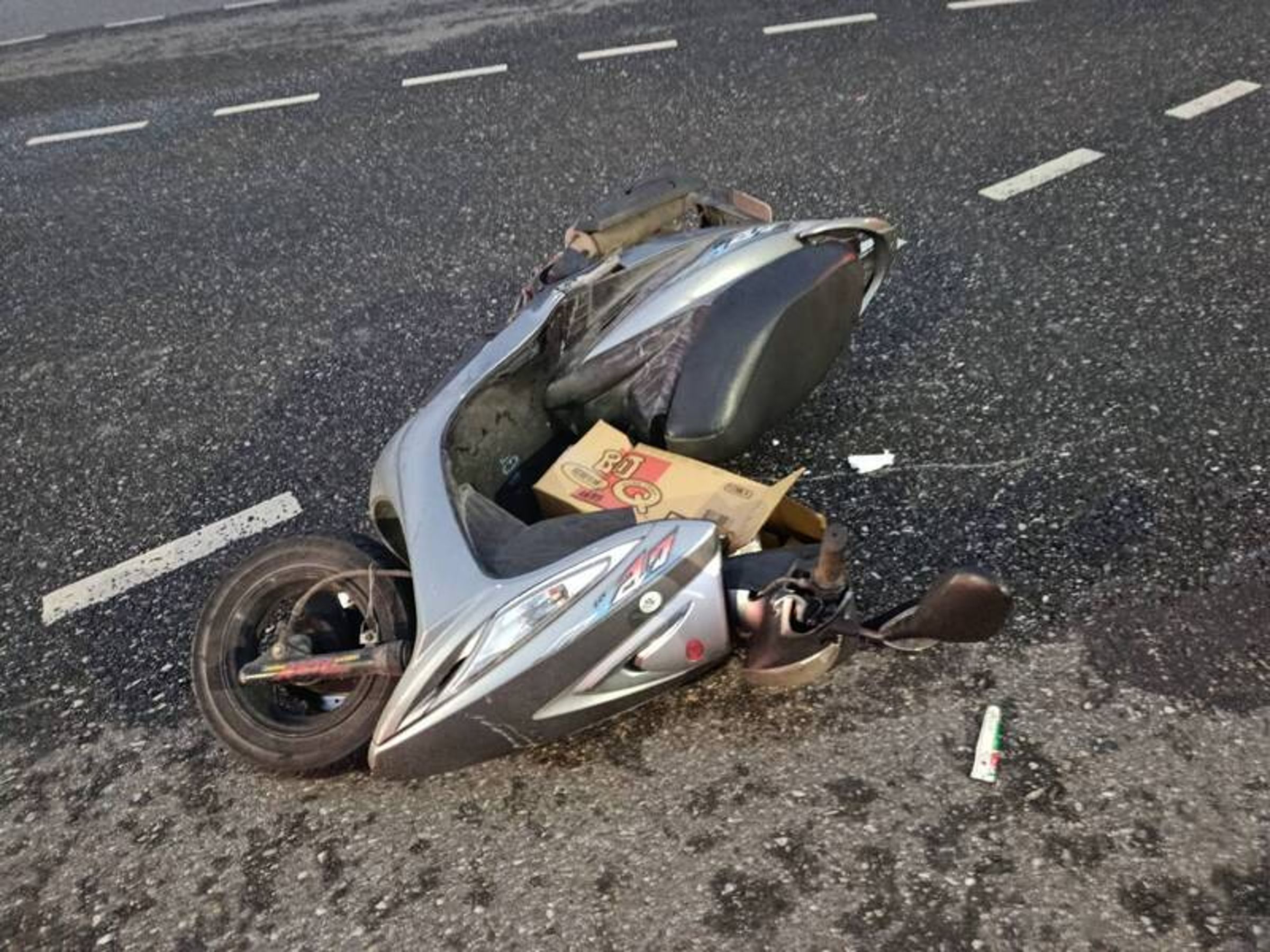 陳姓婦人無照騎乘機車遭撞，機車也因此受到毀損。（翻攝畫面）