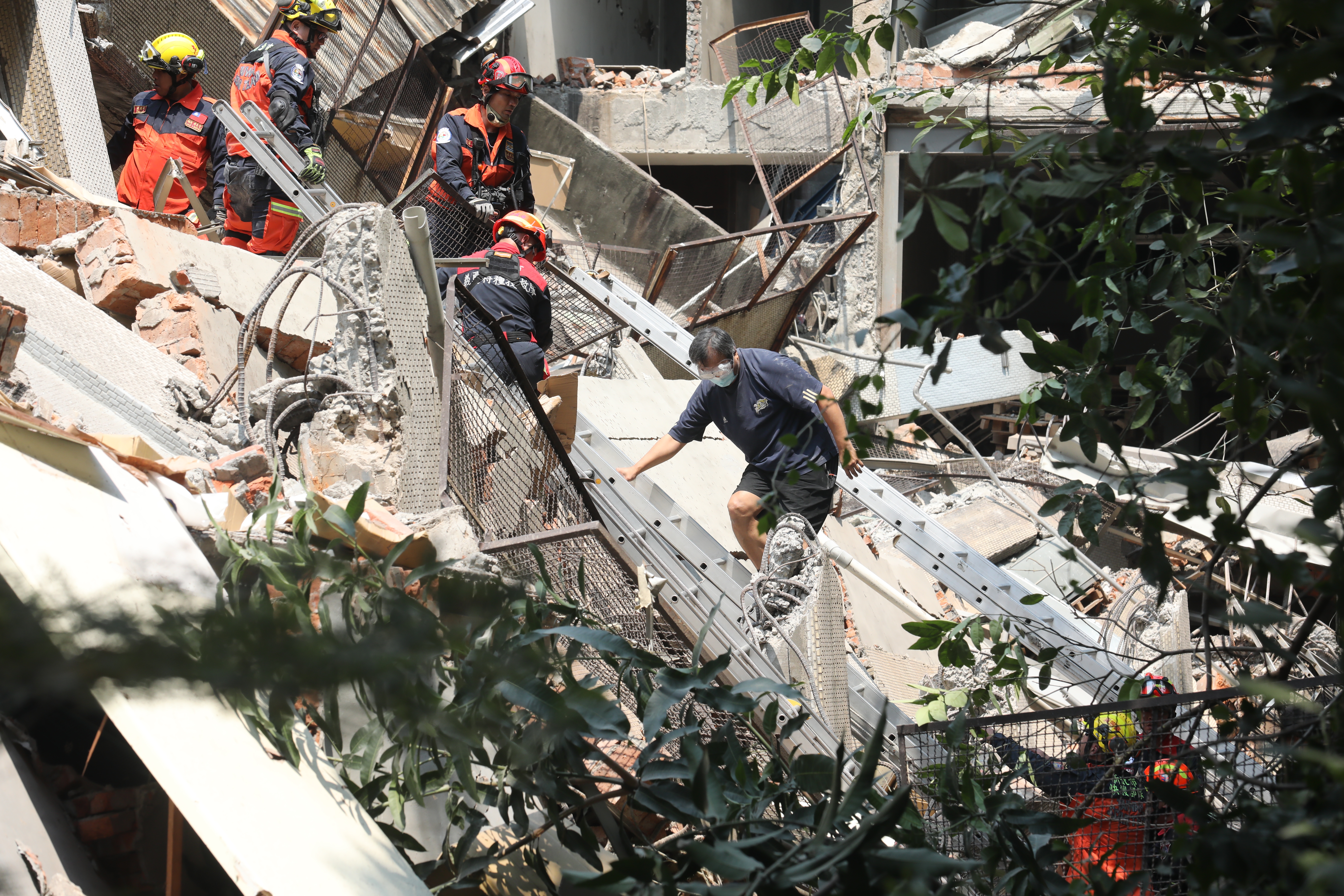 截至中午已4死97傷，各地災情仍陸續傳出，圖為搜救隊在新北土城倒塌倉庫中救出1名員工。