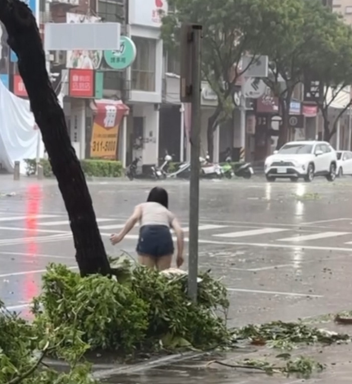 一名熱褲妹冒雨在路上徒手清淤,感動眾多網友。(翻攝threads@yuan.cho)