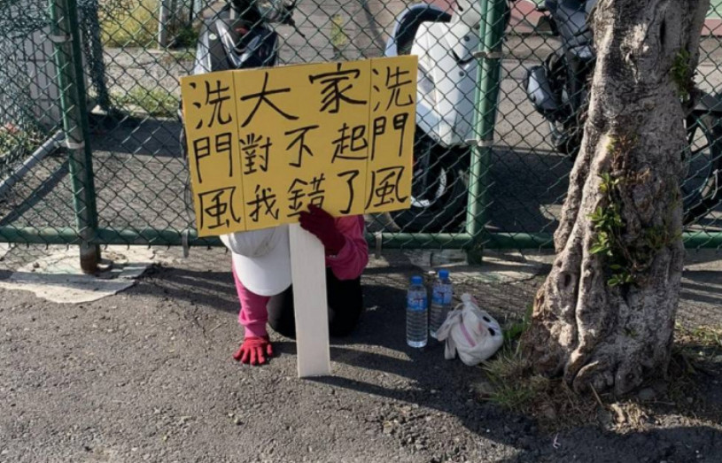 鹿港一名婦人自願跪地舉牌洗門風，警方獲報後前往關切。（翻攝臉書社團「~~我愛鹿港小鎮~~2」）
