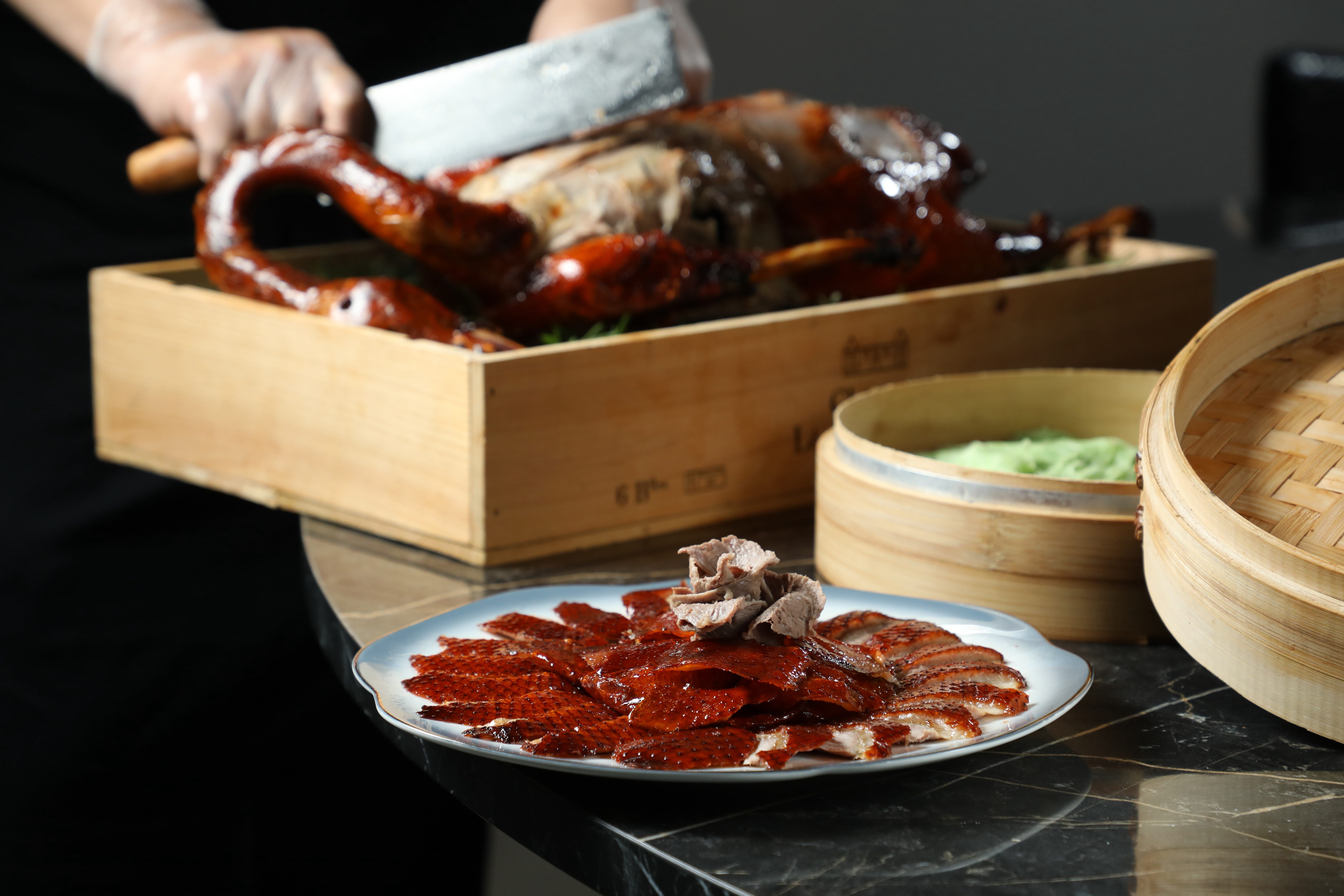 華國招牌菜「明爐金箔燒鵝」以傳統港式燒味工法製作，外皮酥脆油亮。