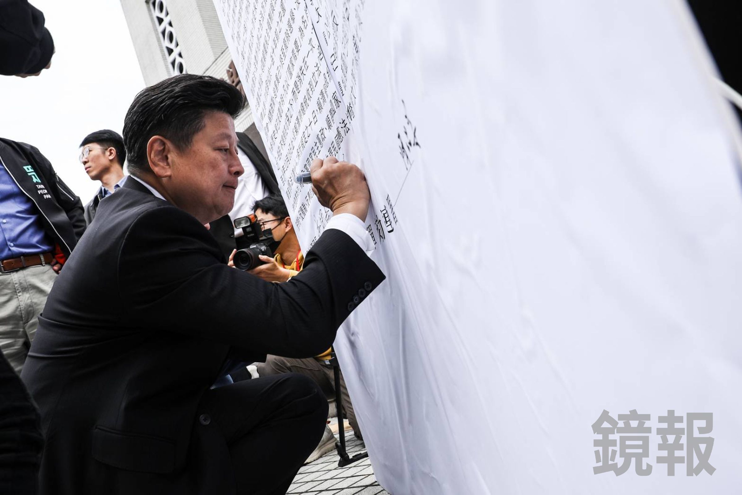現場擺出放大版彈劾全文，立委傅崐萁正在簽名。（鏡報鄒保祥）