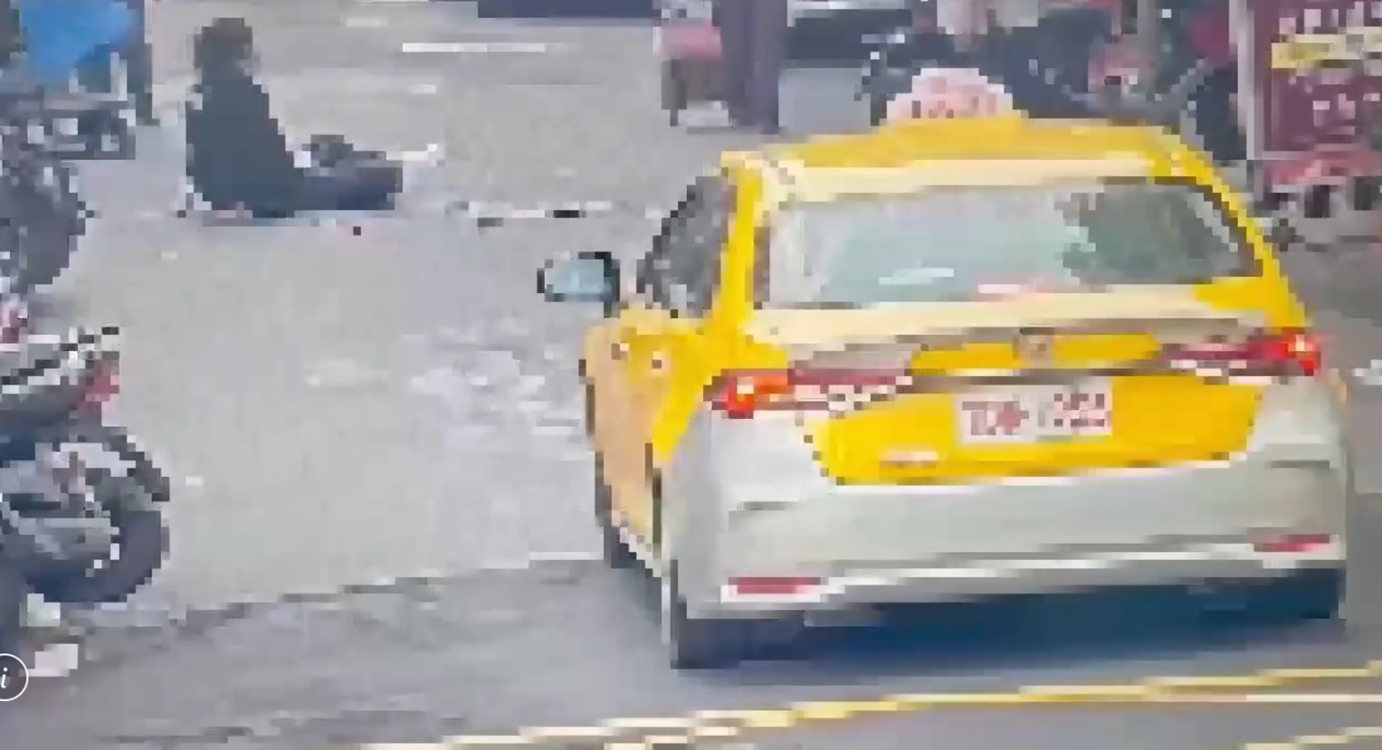 楊男攻擊路人遭過肩摔反制，他一度癱坐在馬路中間喘息。（翻攝畫面）