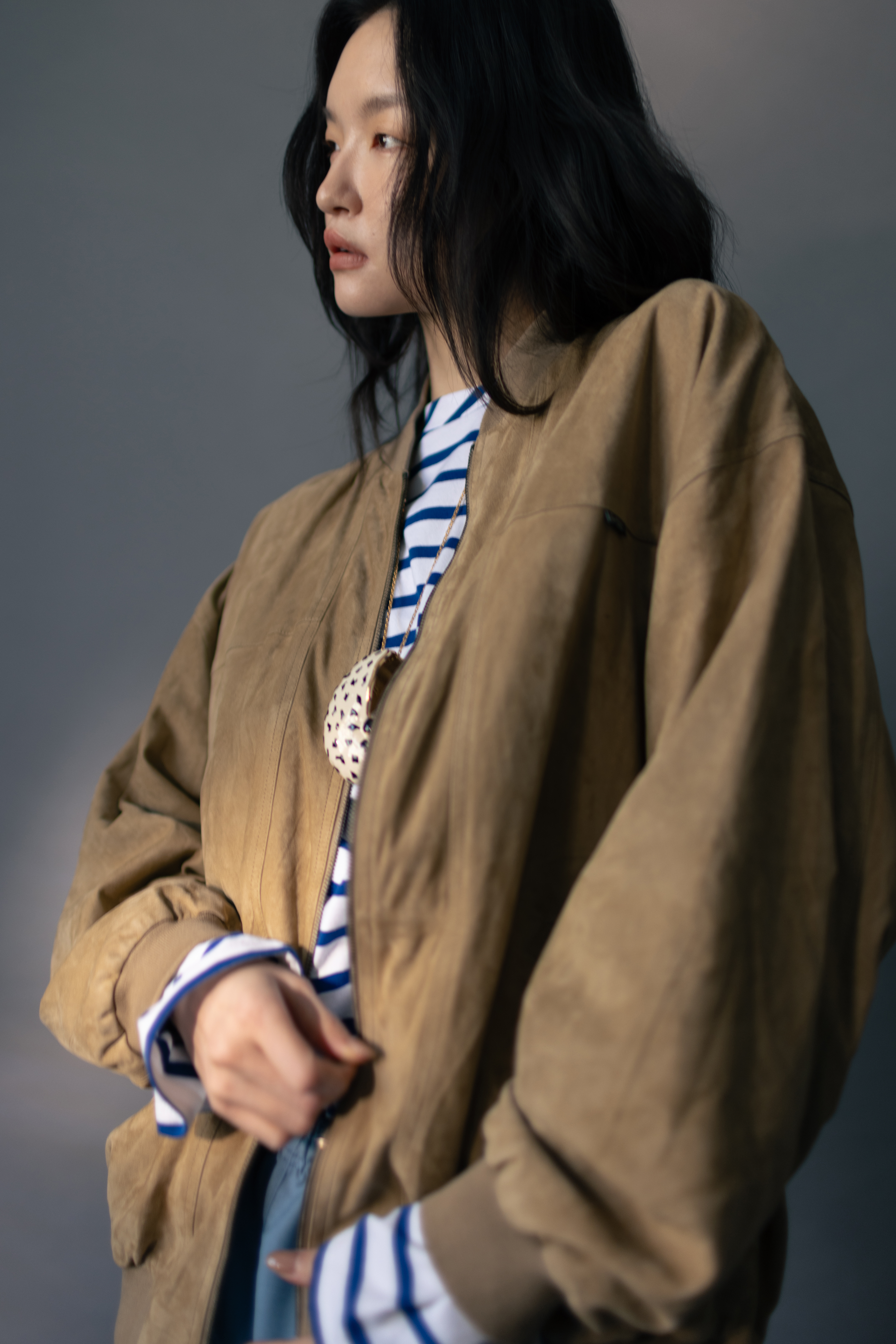 棕色造型外套 價格店洽 by PRADA／條紋上衣 NT$32,500 by CELINE／霧藍膝上短褲 價格店洽 by PRADA／大海螺項鍊 價格店洽 by Loro Piana