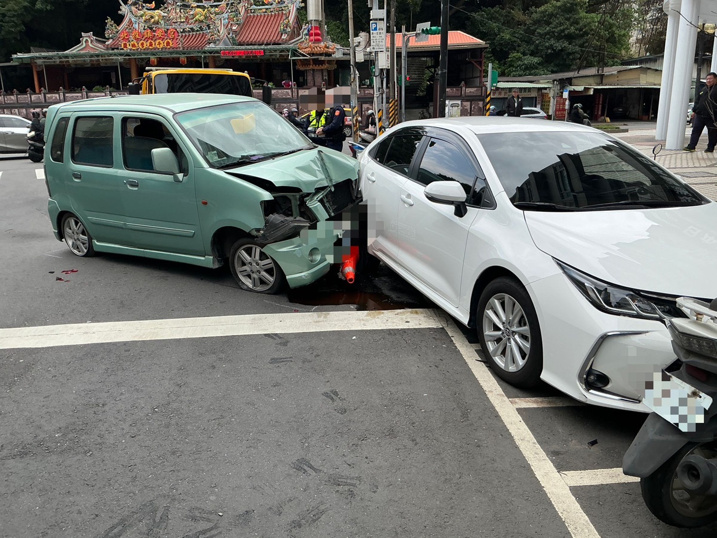 82歲的胡姓老婦人駕車在北投自撞路燈後，並沒有停下來，再追撞白色轎車推至路邊停車格，整個車頭被撞爛。（翻攝畫面）