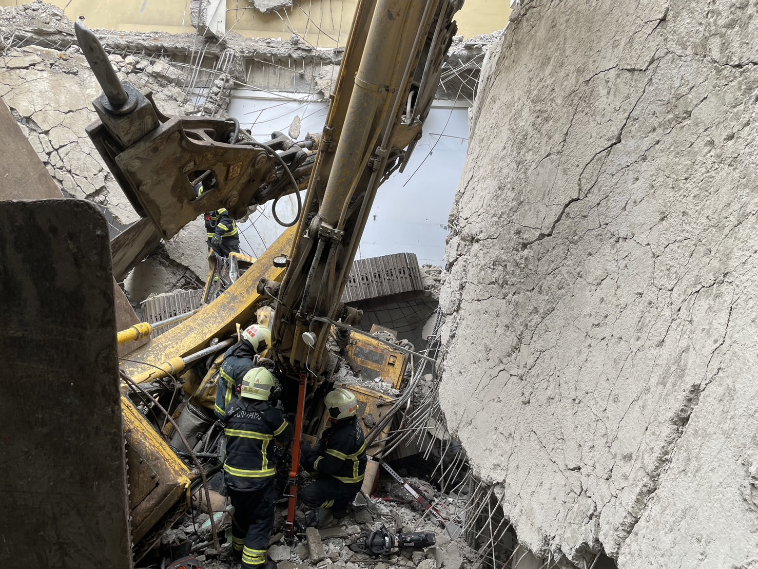 怪手施工時從4樓頂掉落到1樓，駕駛受困車中。（翻攝畫面）