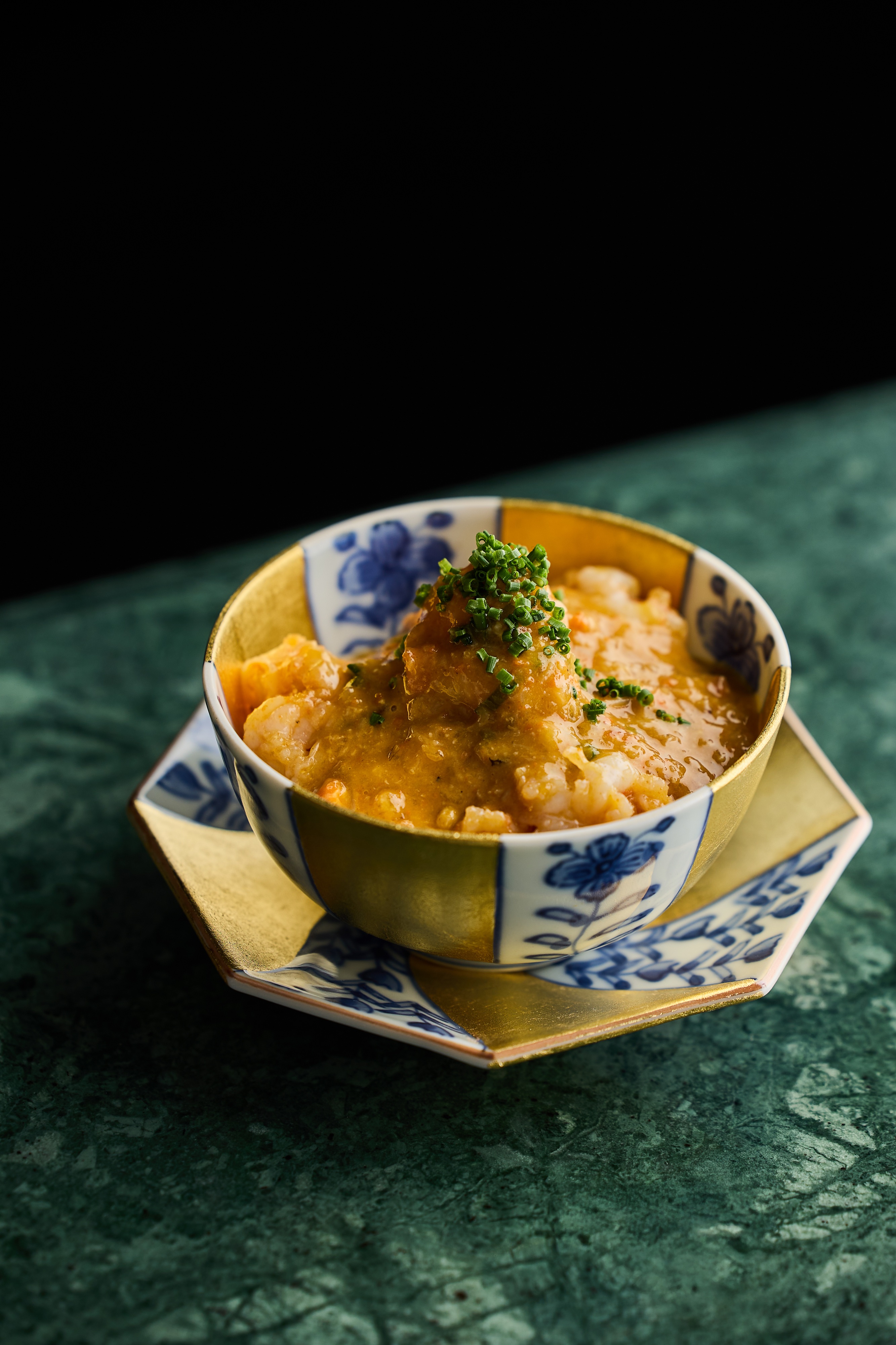 「鮮蟹、蝦、麵」選擇膏肉豐厚的處女蟳和紅蟳，取其蟹膏蟹黃，並加入帝王蟹和紅蟳蟹肉，以及手剝長臂蝦蝦膏炒製成極致鮮濃的蟹粉，搭配油泡蝦仁，淋在以自製紅蔥頭、豬油、醬油和紹興酒拌炒的拉麵上方。（aMaze心宴提供）