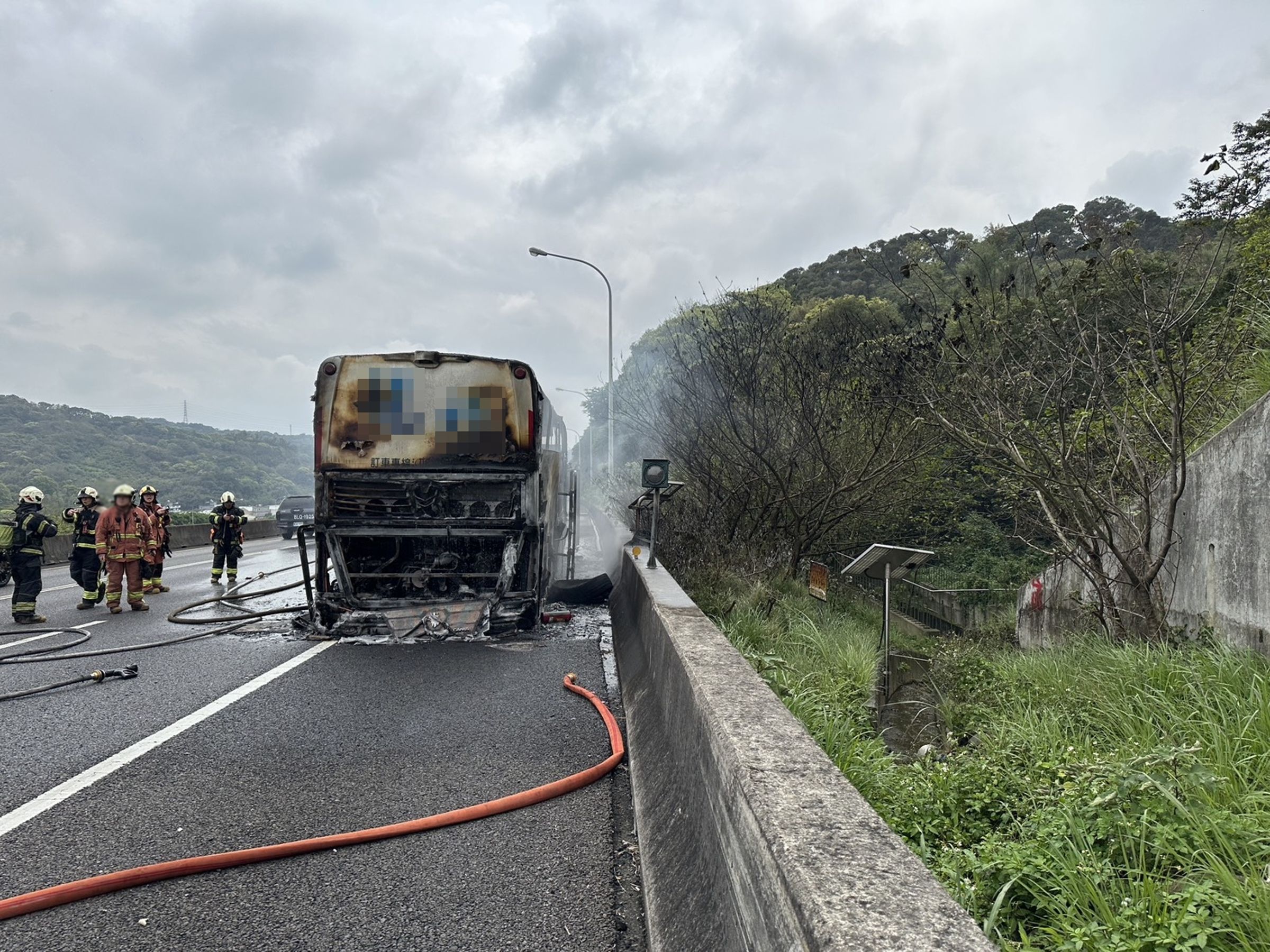 起火點疑似位於遊覽車後方引擎,車體被燒成焦黑嚴重損毀。(翻攝畫面)