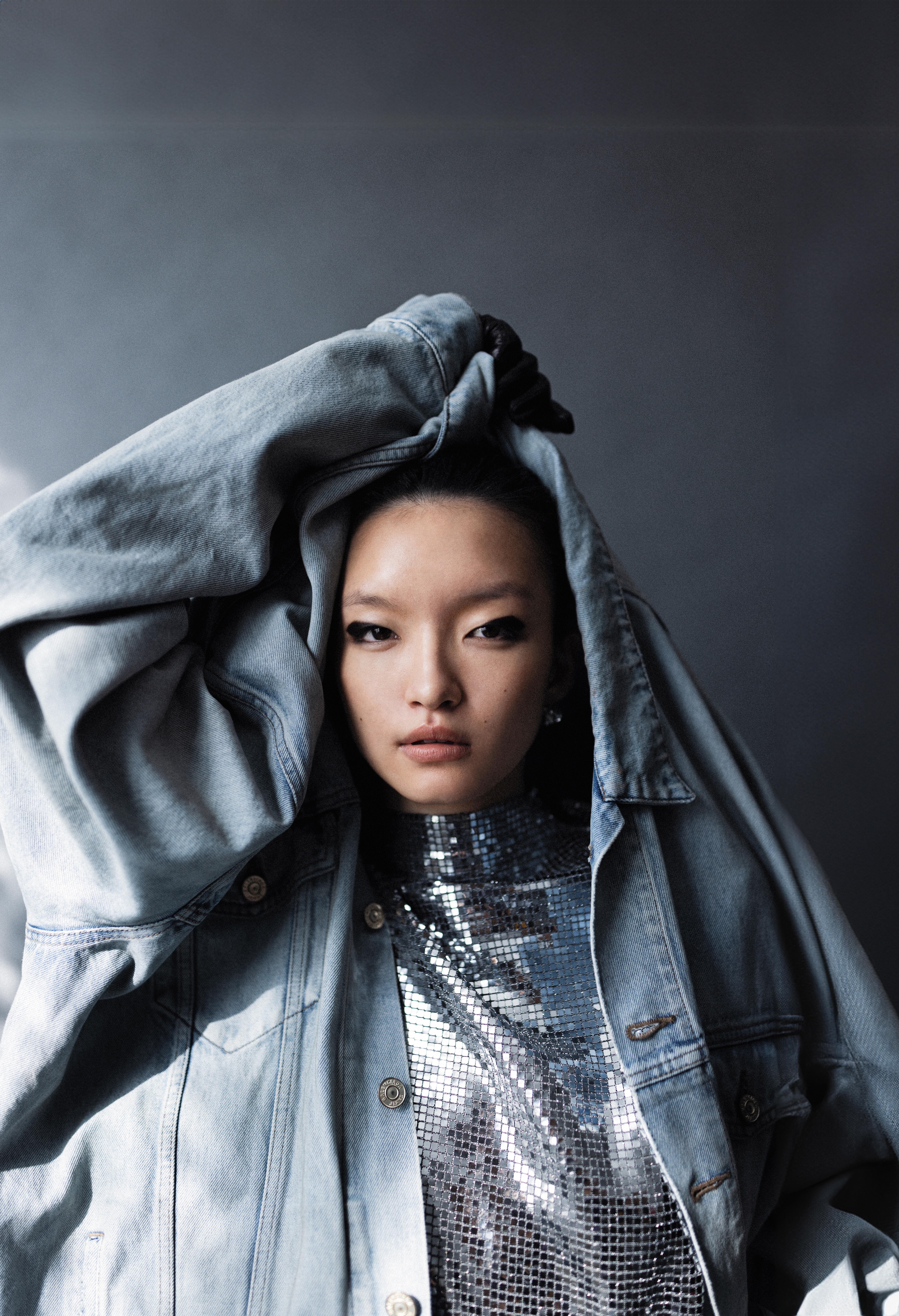 丹寧外套NT$65,000 by BALENCIAGA；銀色金屬感布料上衣 NT$7,490 by maje；銀色耳環 NT$23,000 by LOEWE；Steph黑色小羊皮手套 價格店洽 by Chloé。