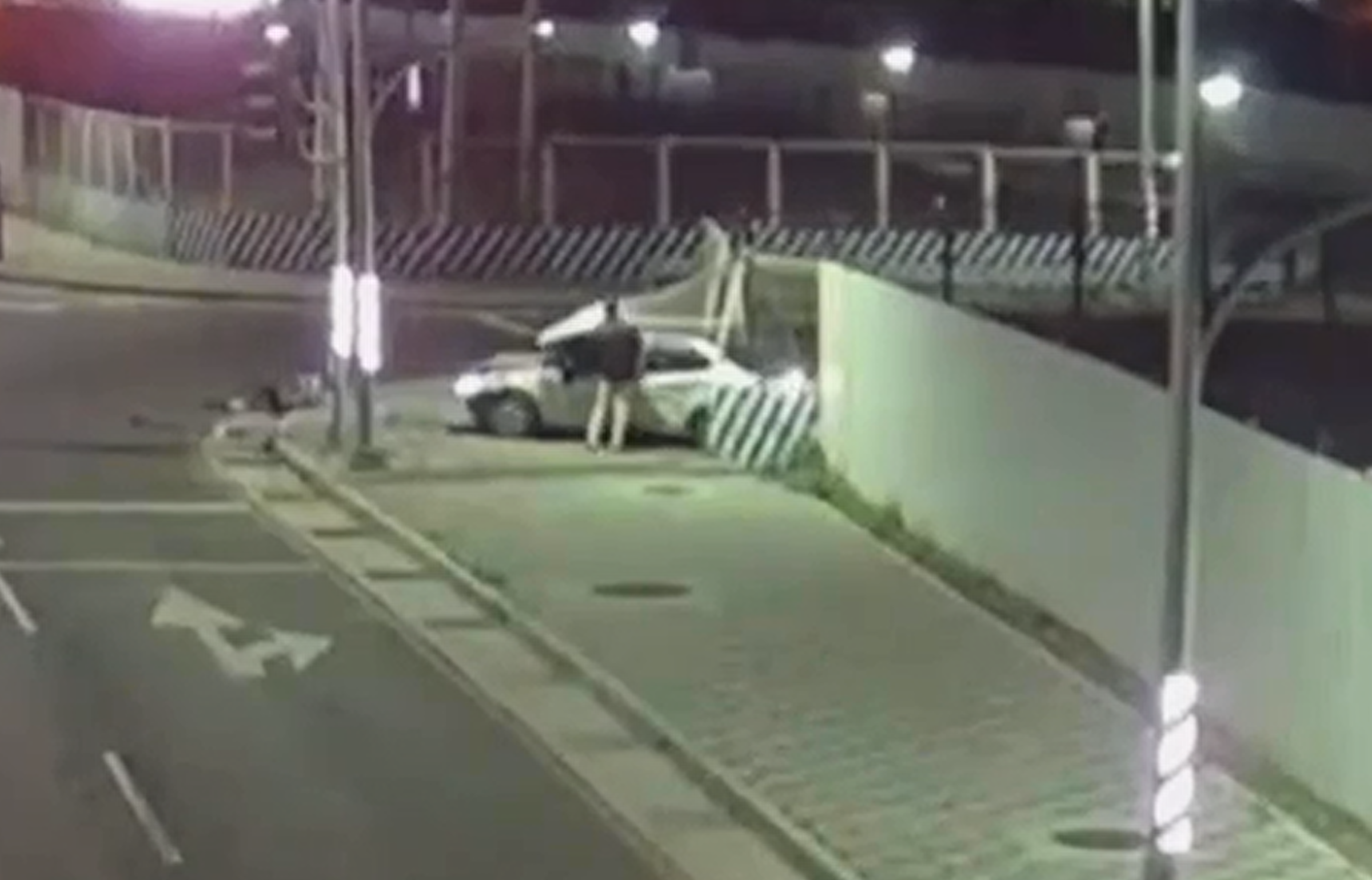 駕駛撞爛圍籬後，一度下車查看，並將卡在擋風玻璃的厚重圍籬拭圖移開。（警方提供）