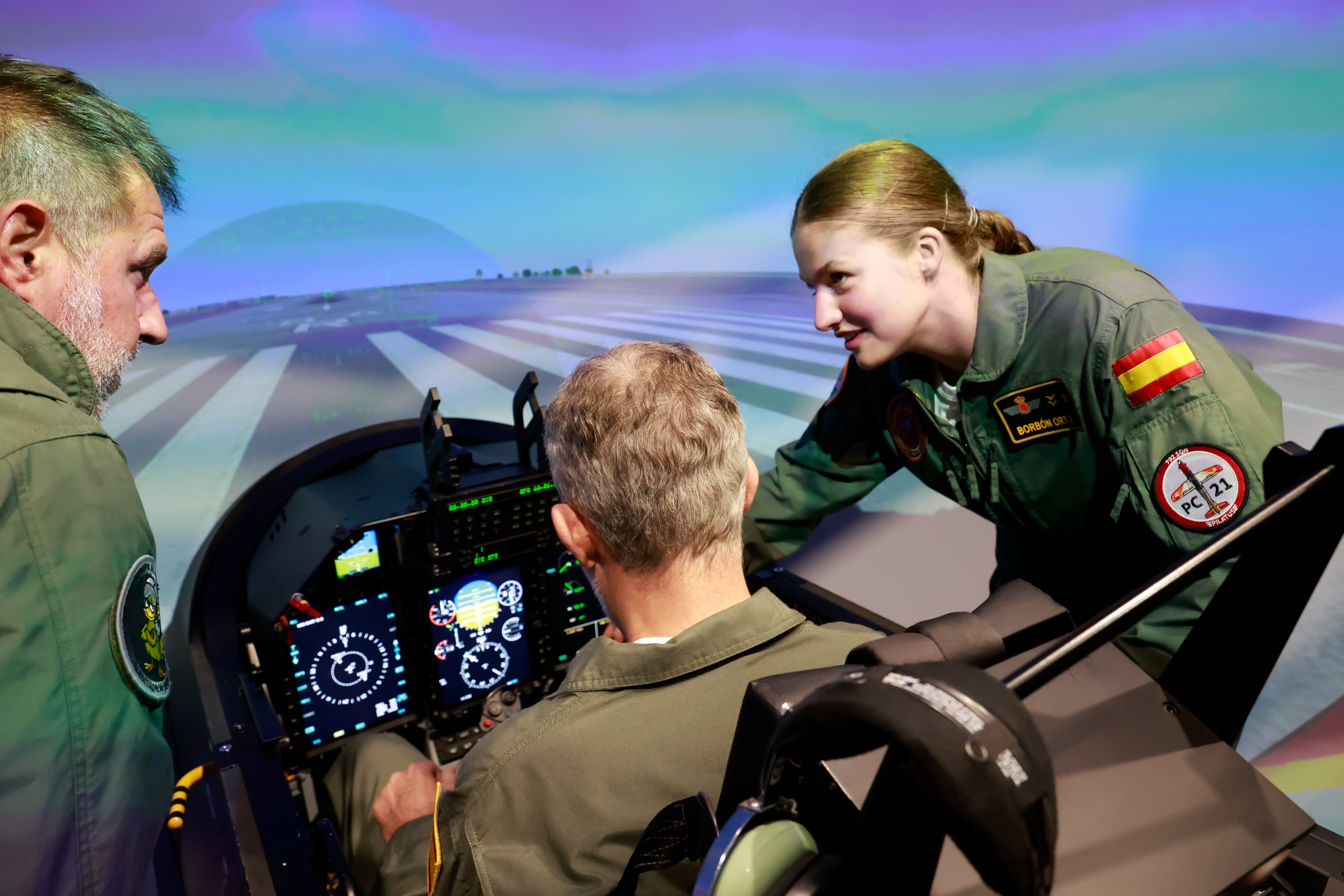 萊昂諾公主身穿飛行服,在模擬飛行中心向國王費利佩六世說明飛行訓練內容。(翻攝X@CasaReal)