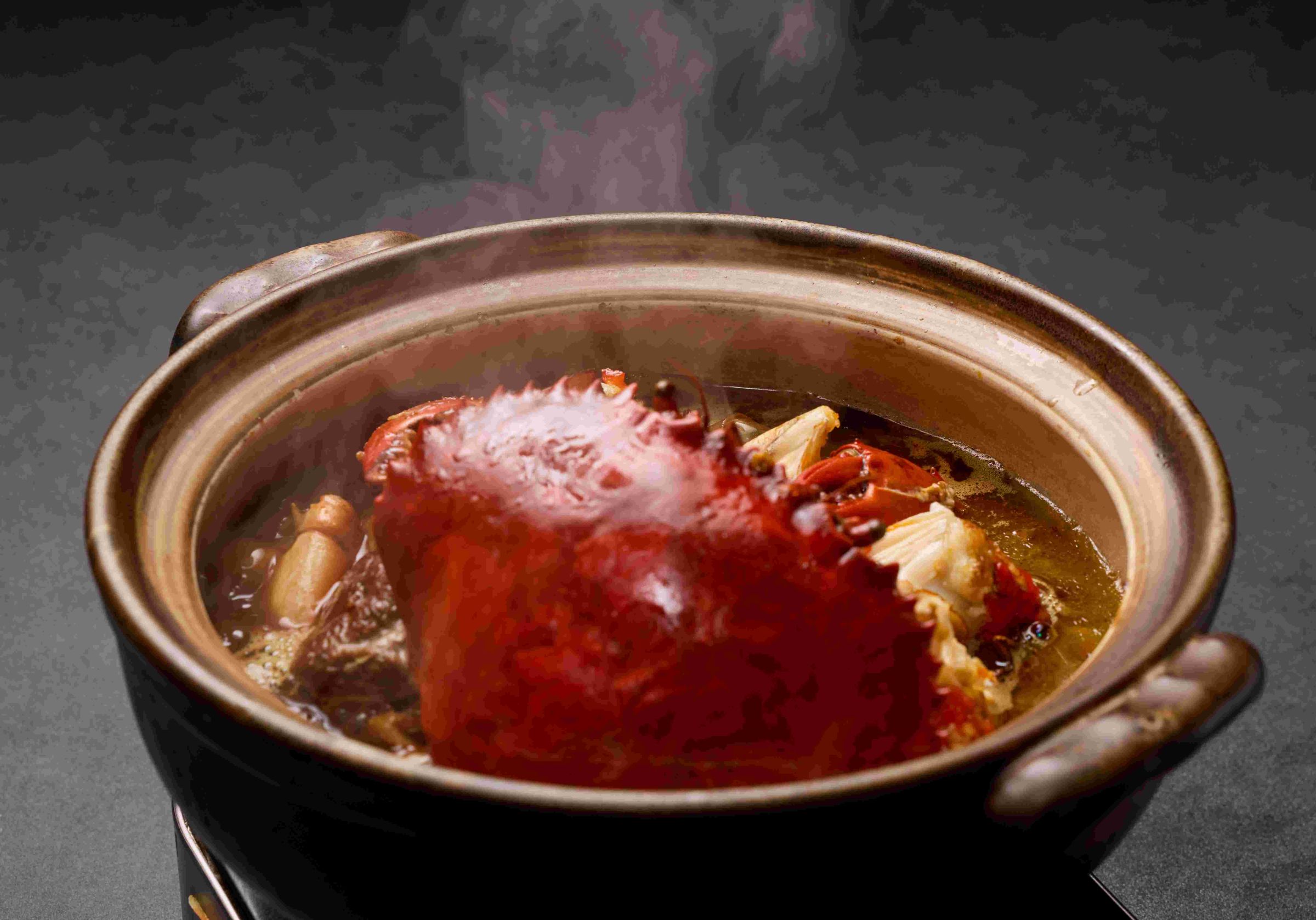 「紅蟳乾燒薑母鴨」以麻油爆香老薑，將鴨肉與杏鮑菇煎至表面金黃，加入米酒與雞骨湯煨煮，最後放入紅蟳大火收汁，海味鮮甜與麻油薑香緊緊環扣。（2,288元／份）（玖尹提供）