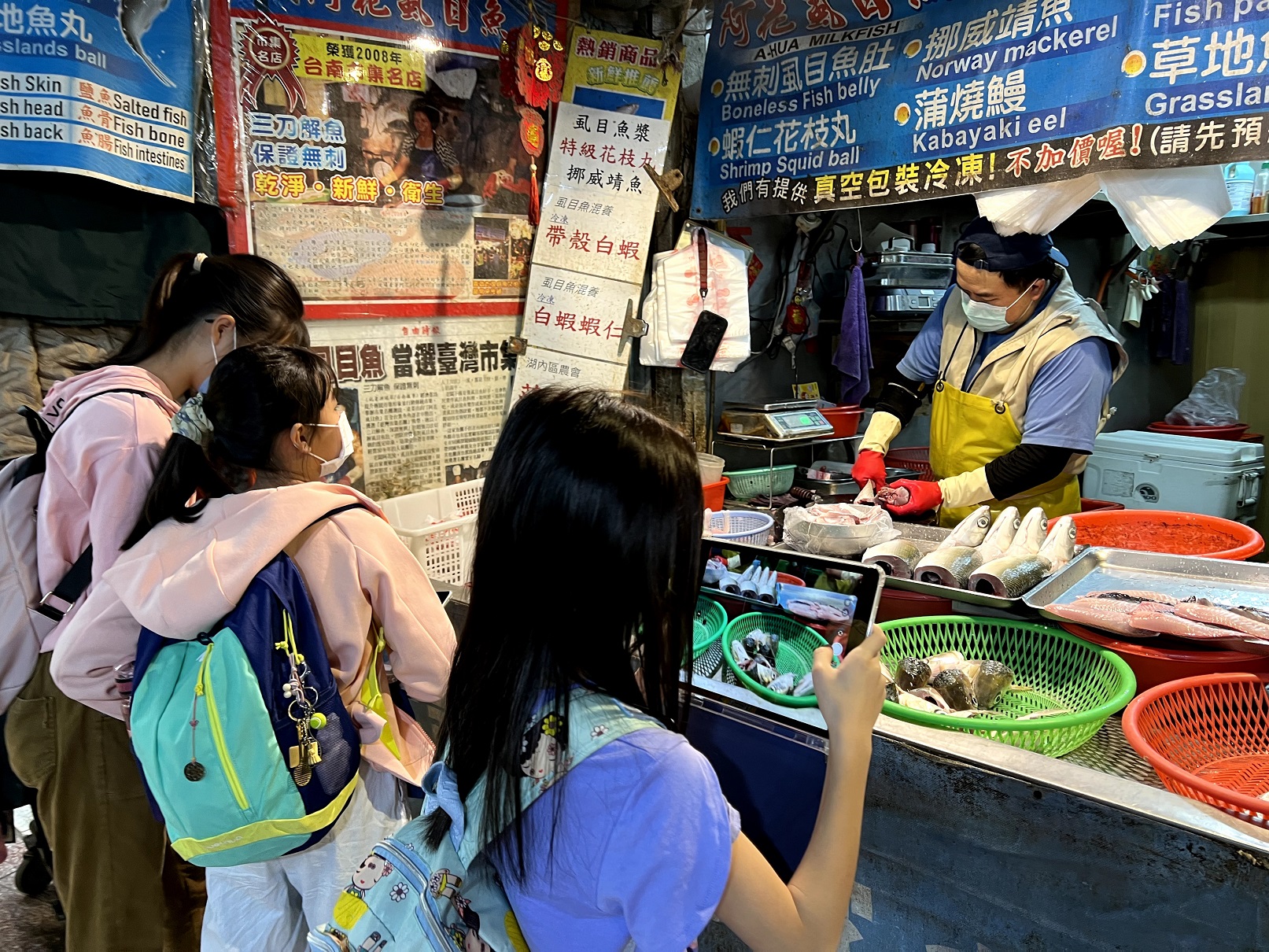 學生帶著平板走訪百年傳統市場，透過買賣和觀察記錄，讓攤商與學生之間展開一場難得的溝通，成功串起跨世代的社區營造。（黃雅貴提供）