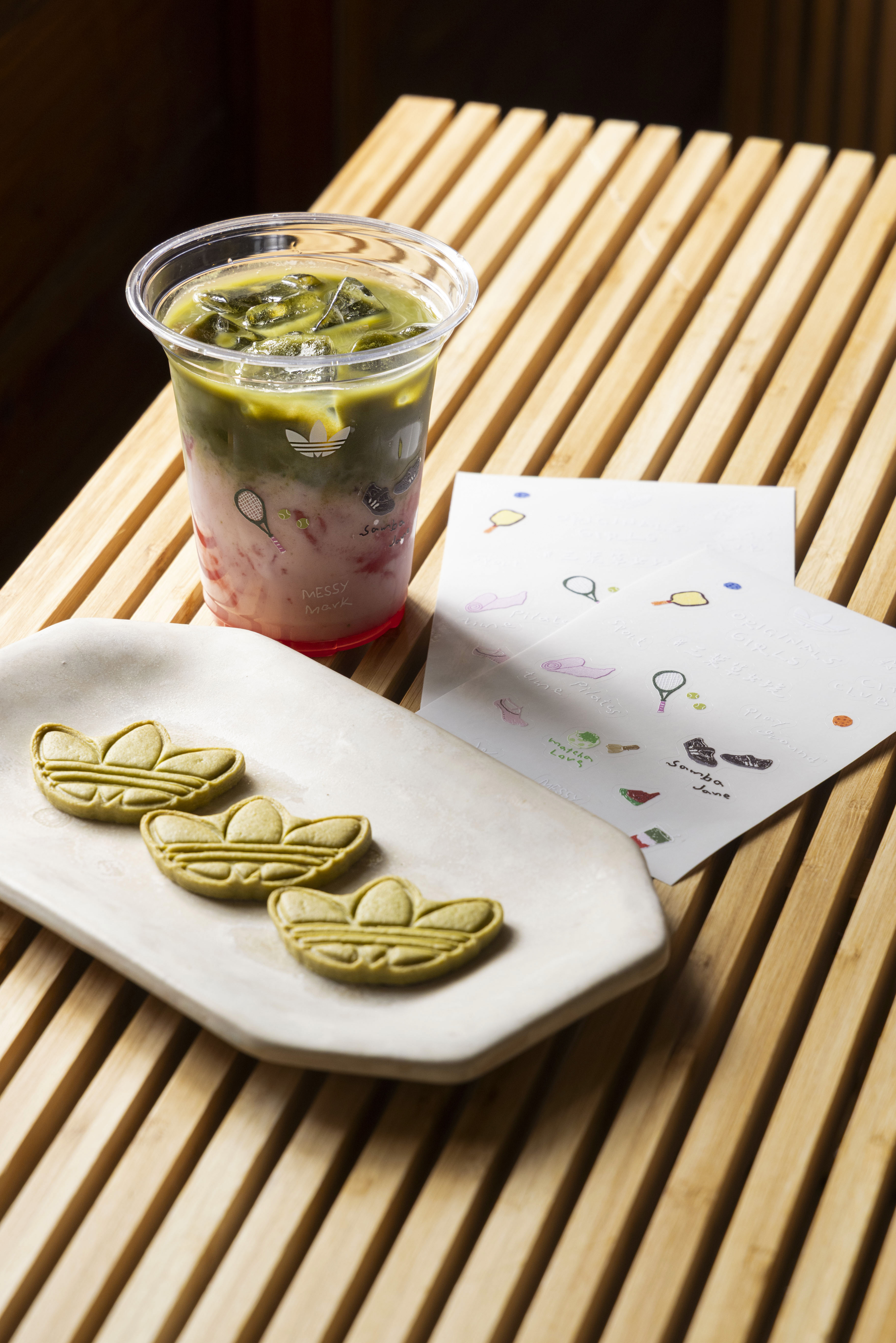 Originals Café限定飲品抹茶西瓜椰乳、adidas Originals × Messy Mark塗鴉貼紙，能感受咖啡文化x手作體驗與三葉草女孩的風格日常。（adidas Originals提供）       