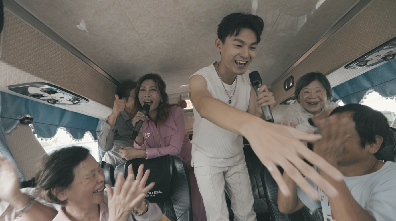 為了拍〈幸福遊覽車〉MV，羅梓華與陳燕萍在遊覽車上實景拍攝。（威爾斯葛羅提供）