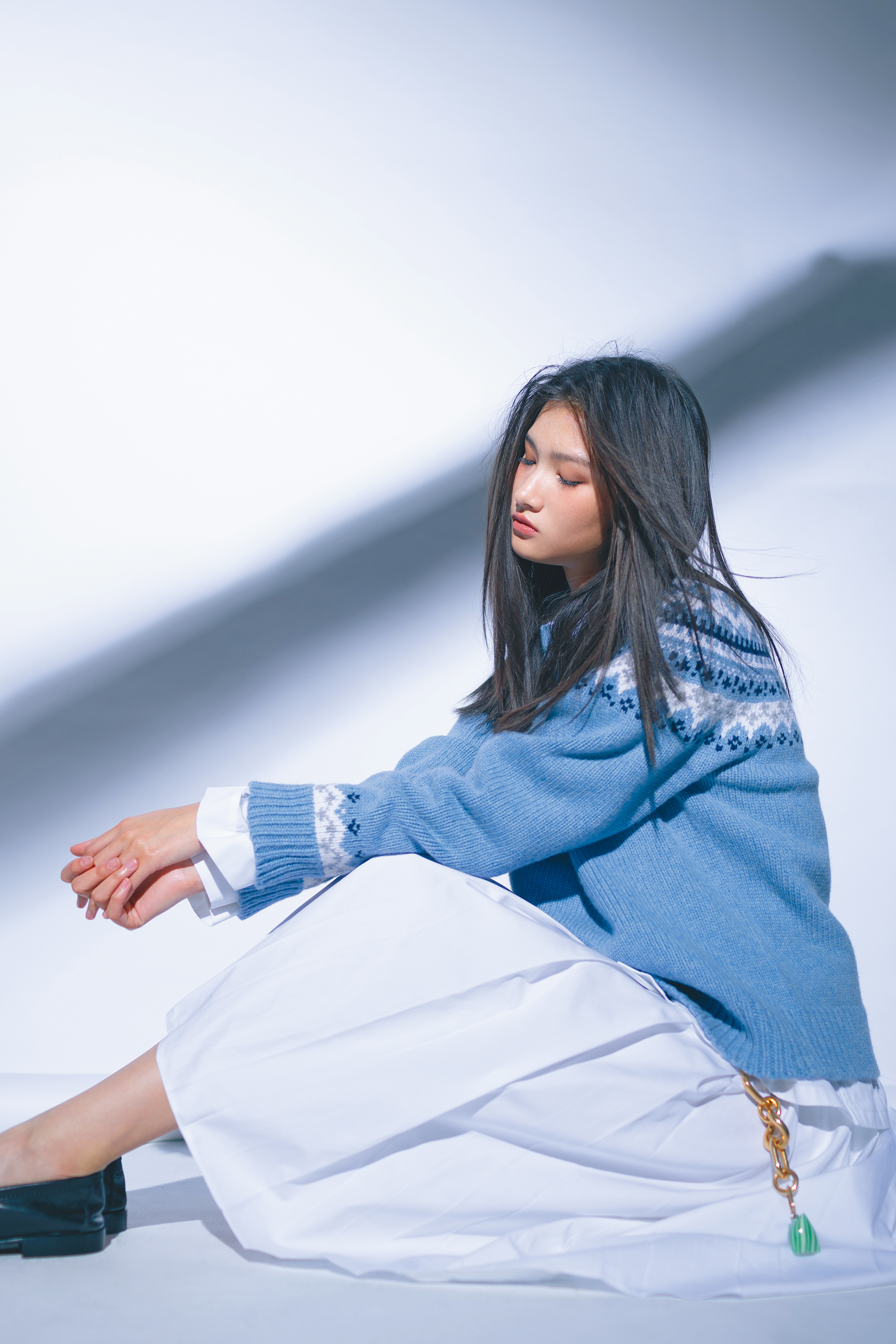 藍色羊毛上衣 價格店洽 by MIU MIU；白色棉質襯衫 價格店洽 by MIU MIU；白色棉質及膝百褶裙 價格店洽 by PRADA；樂福鞋 NT$38,000 by MIU MIU；MODERN金色飾面粗飾鍊 NT$48,500 by CELINE；BERLINGOT綠色吊飾 NT$15,500 by CELINE。