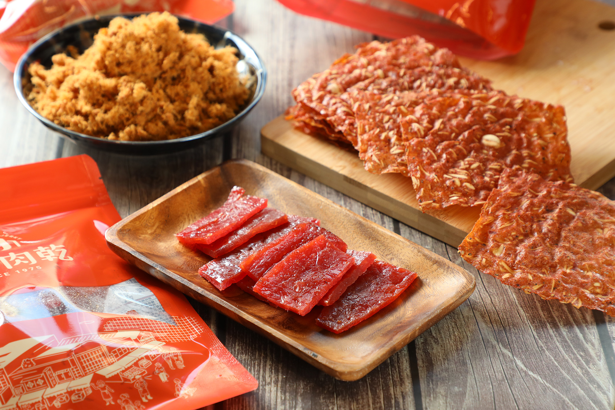 「原味豬肉乾」（中，420元／台斤）、「原味酥脆杏仁豬肉乾」（右上，120元／包）與「原味肉鬆」（左上，360元／台斤）是三哥肉乾最受歡迎的三大伴手禮。