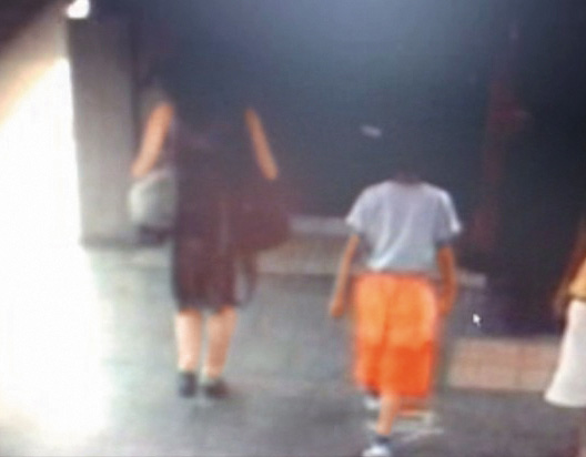 曾女帶9歲兒子到汐止火車站時，監視器錄下最後身影。（翻攝畫面）