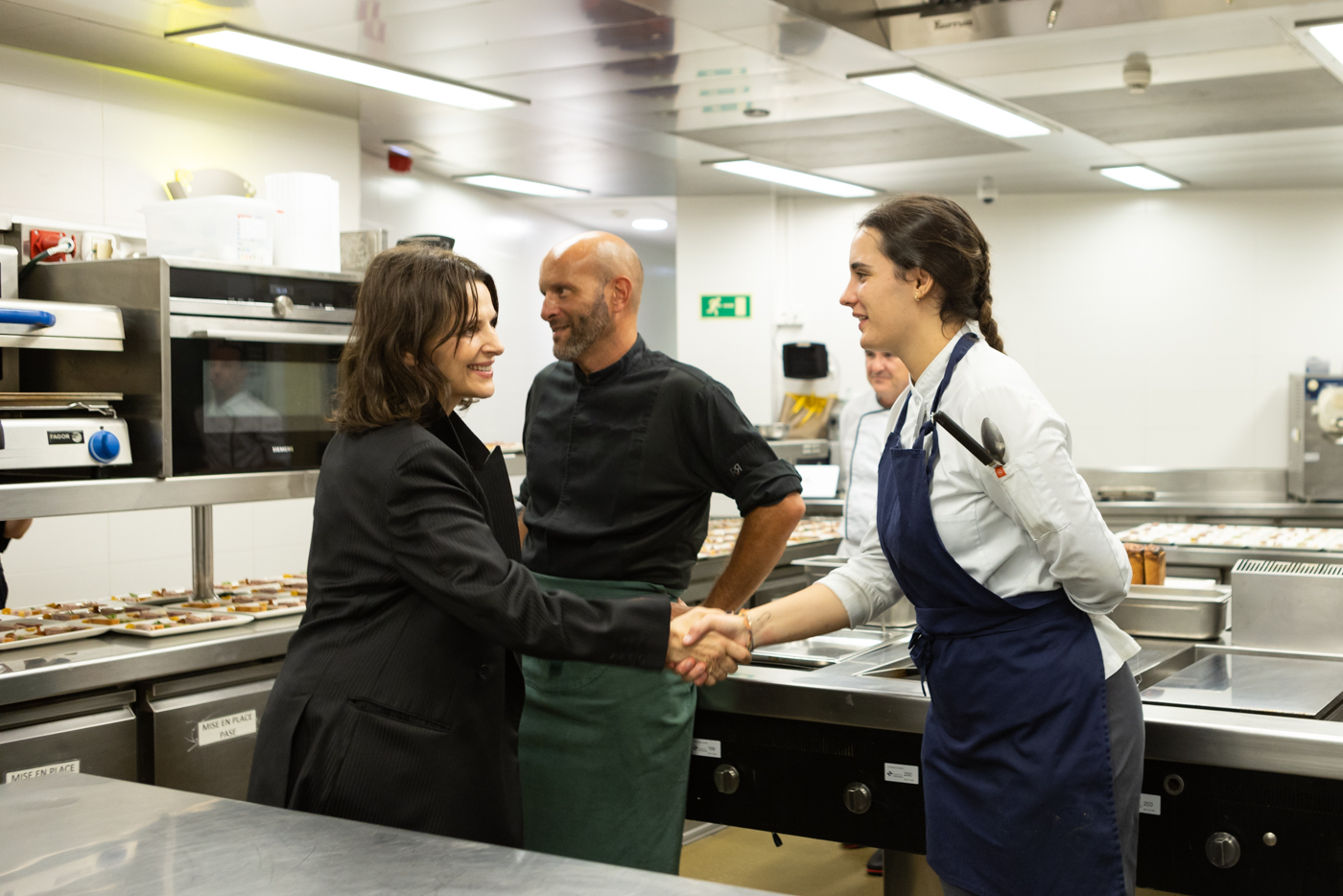 茱莉葉畢諾許（左）主演去年Culinary Zinema單元閉幕片《火上鍋》，親自向準備餐點的工作人員致意。 （翻攝自sansebastianfestival.com）